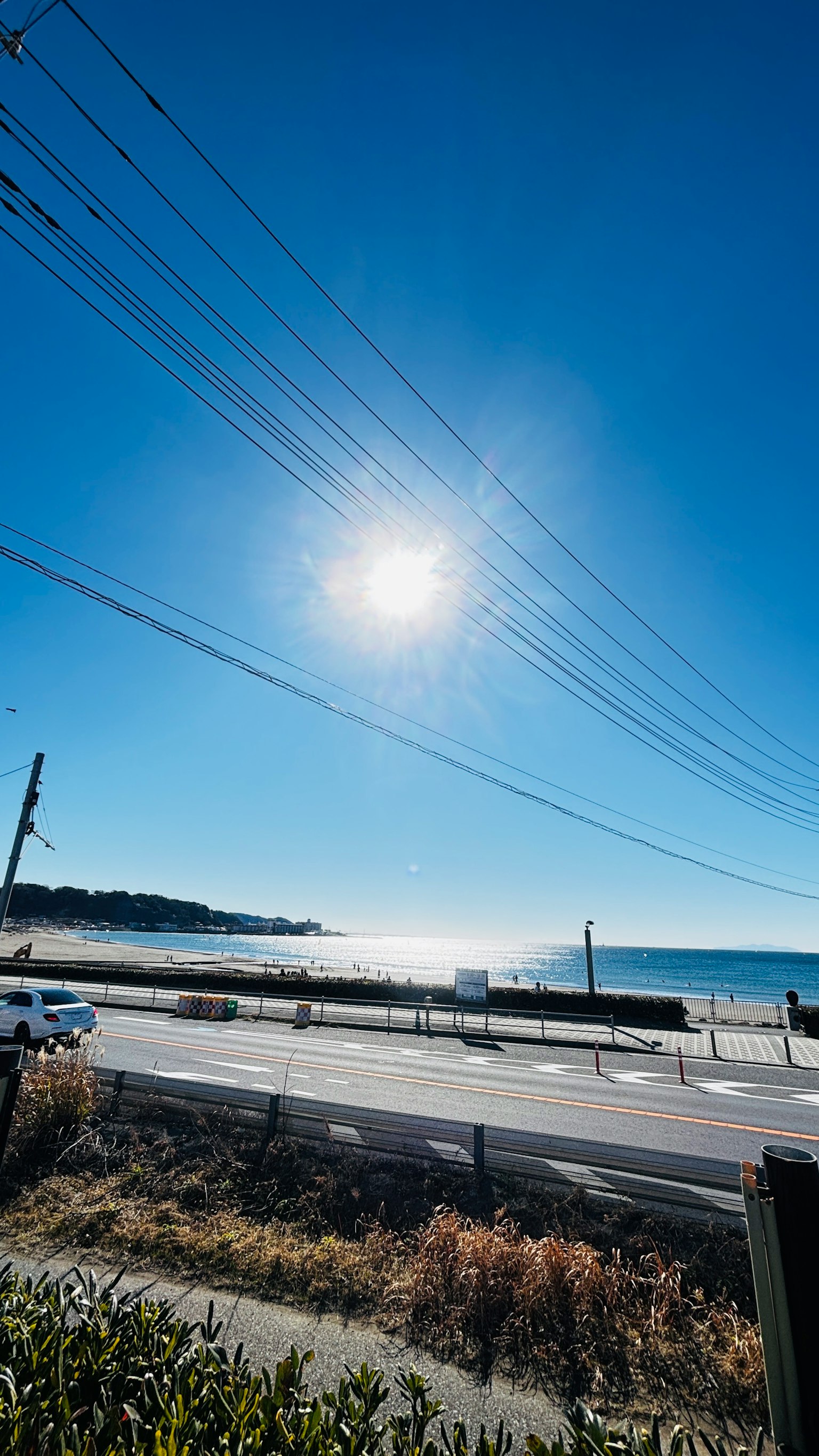 Malersiche Aussicht auf den Ozean und die Straße unter einem klaren blauen Himmel mit einer strahlenden Sonne