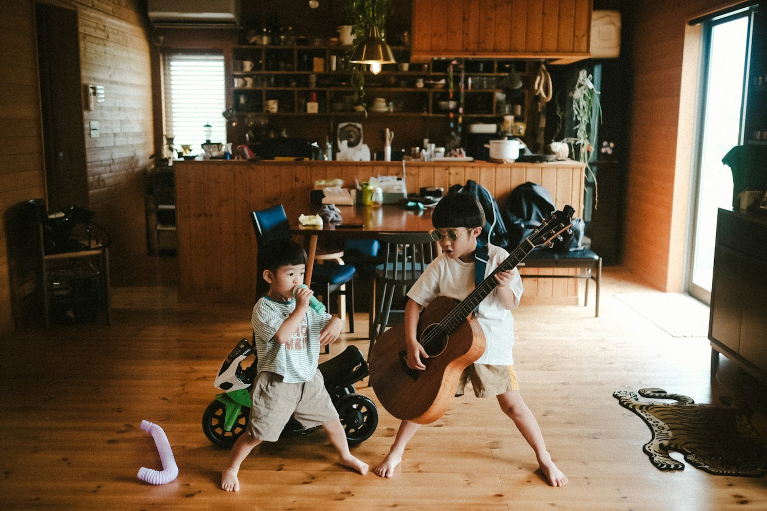 Kinder spielen mit Musikinstrumenten in einem gemütlichen Wohnzimmer