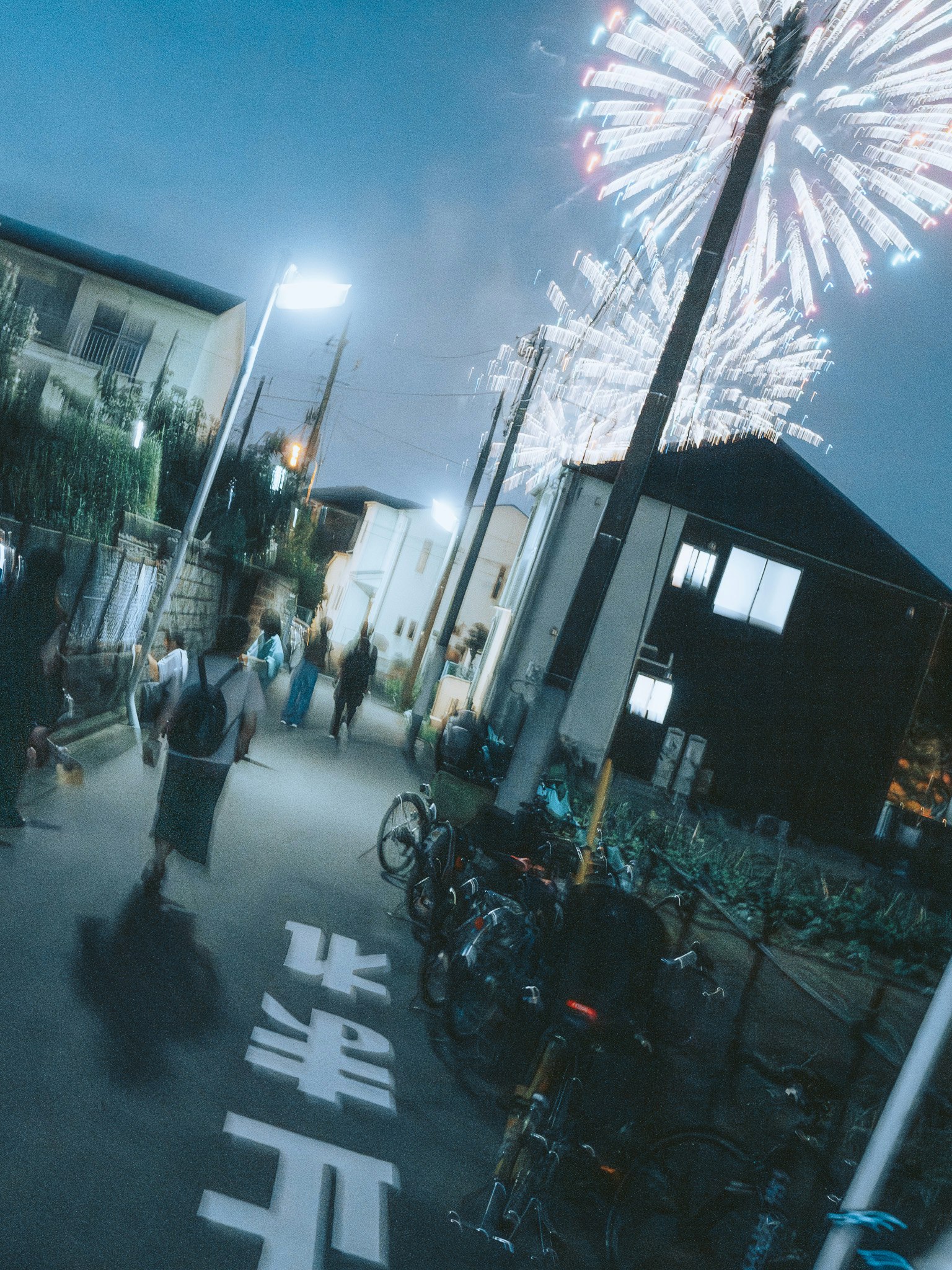 人們在夜空中有煙火的街道上行走