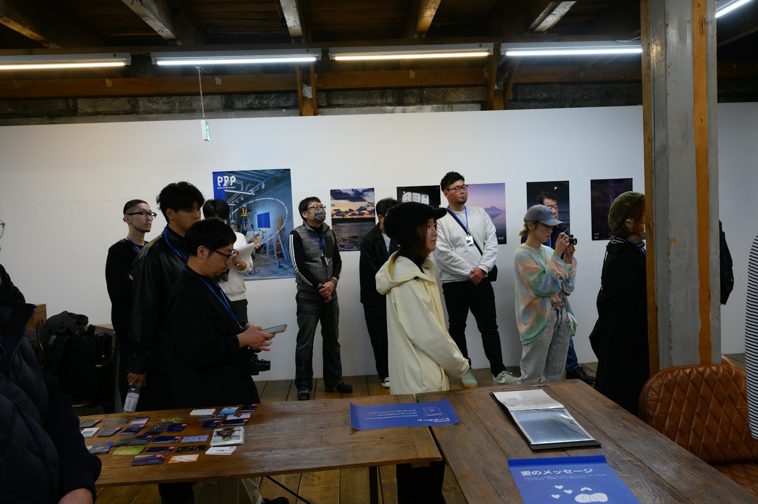 Público observando obras de arte en una exposición con varios carteles en la pared