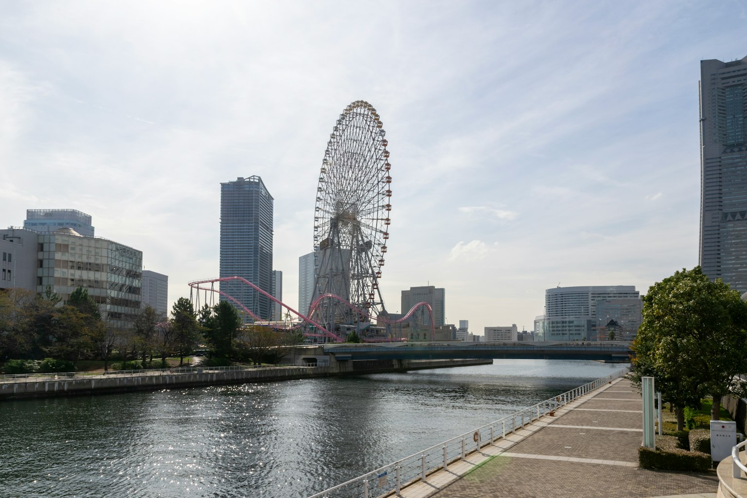 Paysage de Yokohama avec une grande roue et une rivière entourée de bâtiments modernes