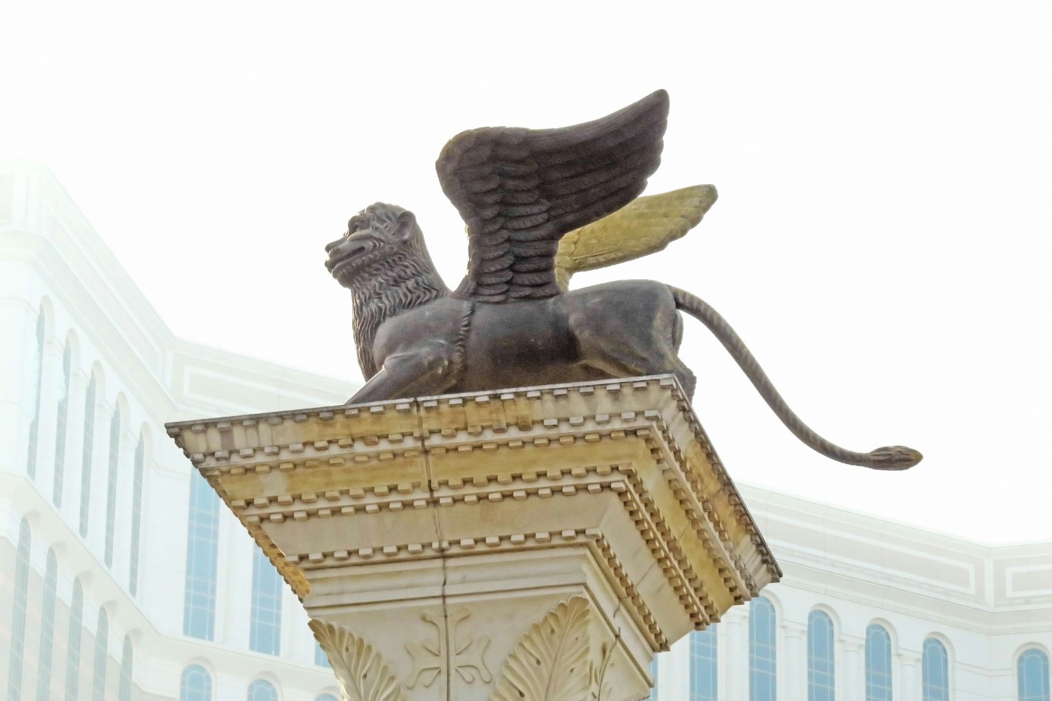 Estatua de león alado sobre una columna