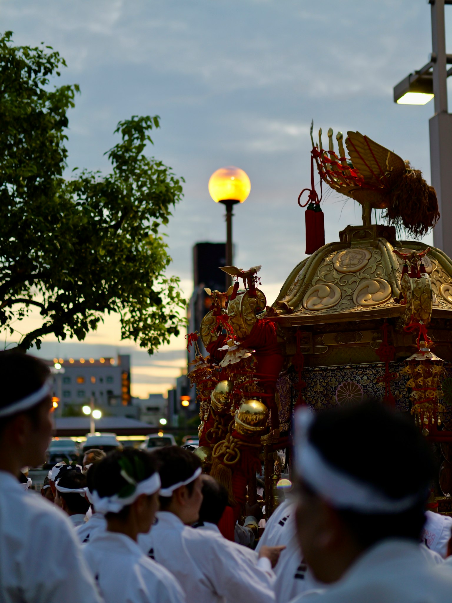 ฝูงชนที่ถือศาลเจ้าตกแต่งในช่วงพระอาทิตย์ตก