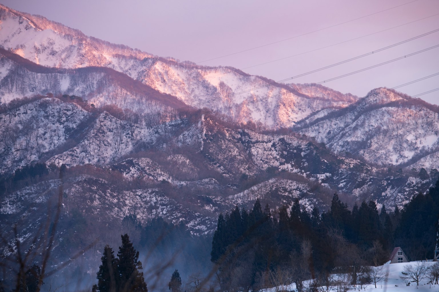 Bellissimo paesaggio di montagne innevate che riflettono i colori del tramonto