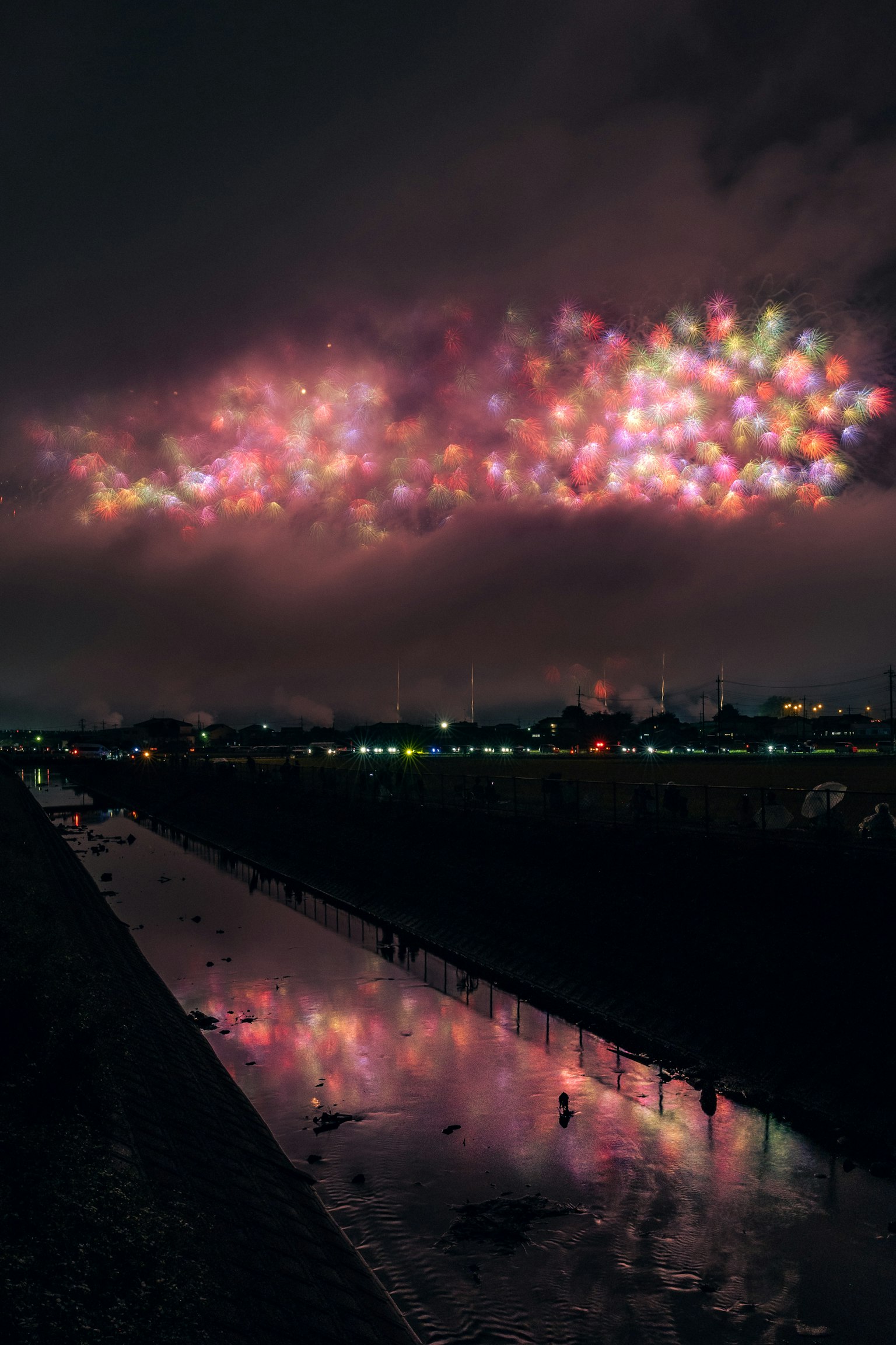 Nuvole luminose colorate nel cielo notturno riflesse su un fiume