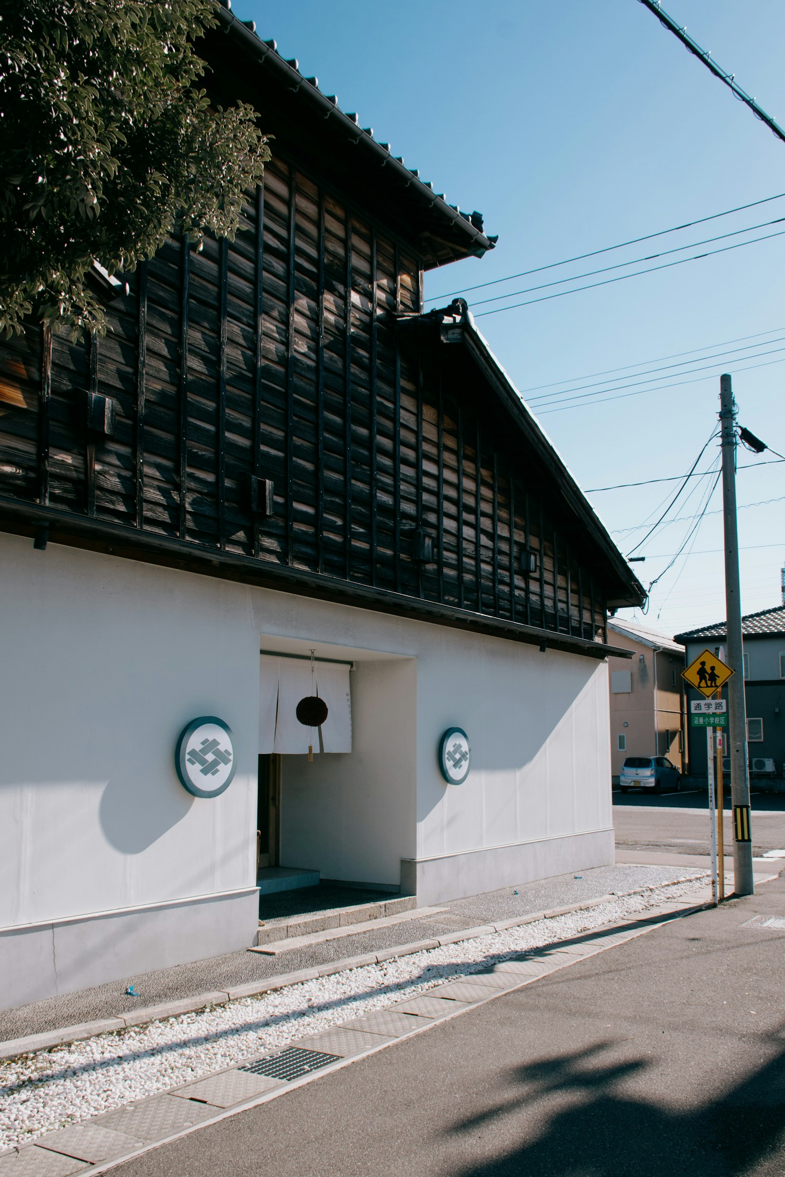 Esterno di un edificio tradizionale giapponese con tetto in legno muri bianchi e simboli circolari