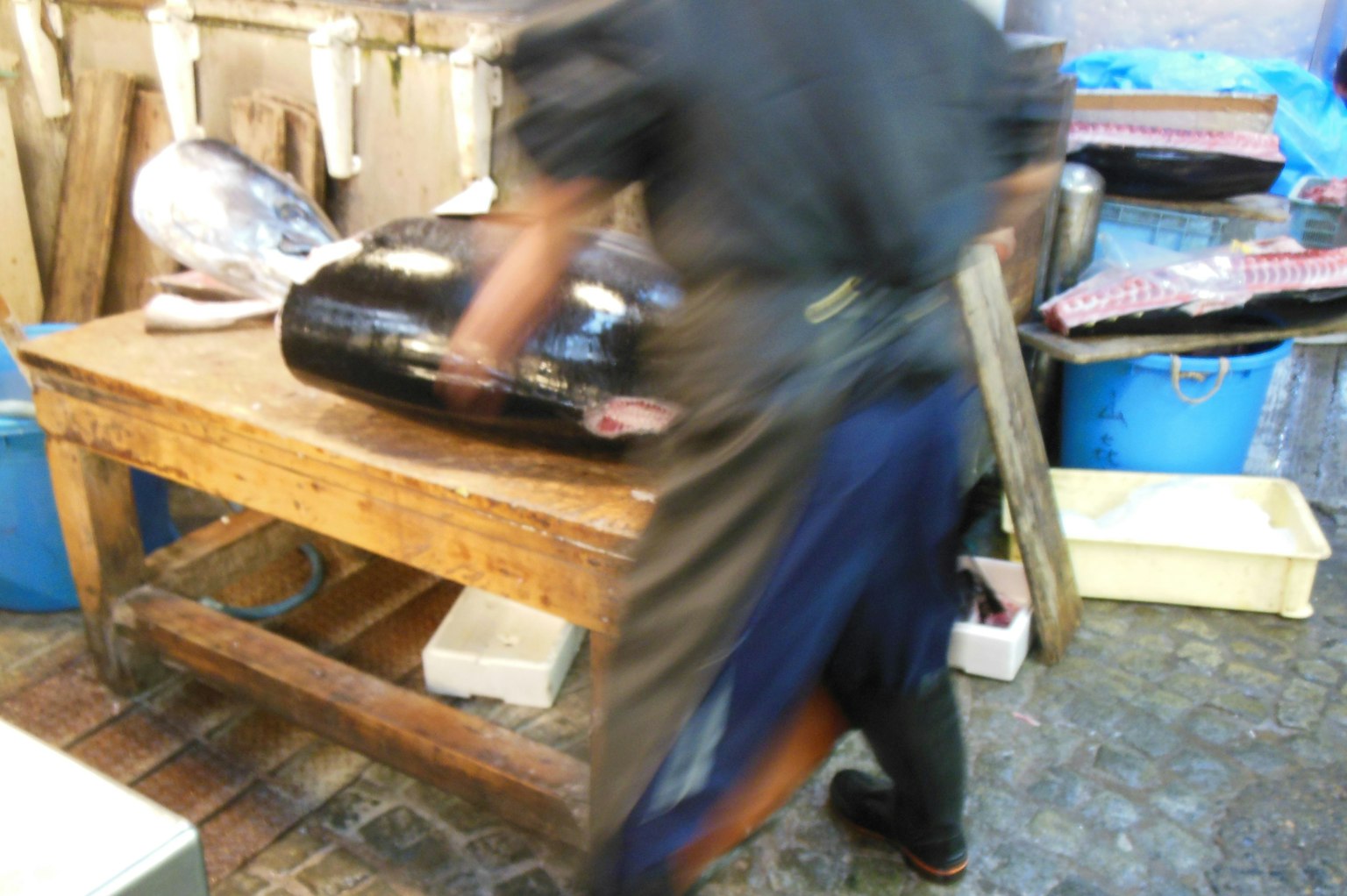 Un pescadero cortando hábilmente pescado en un mercado