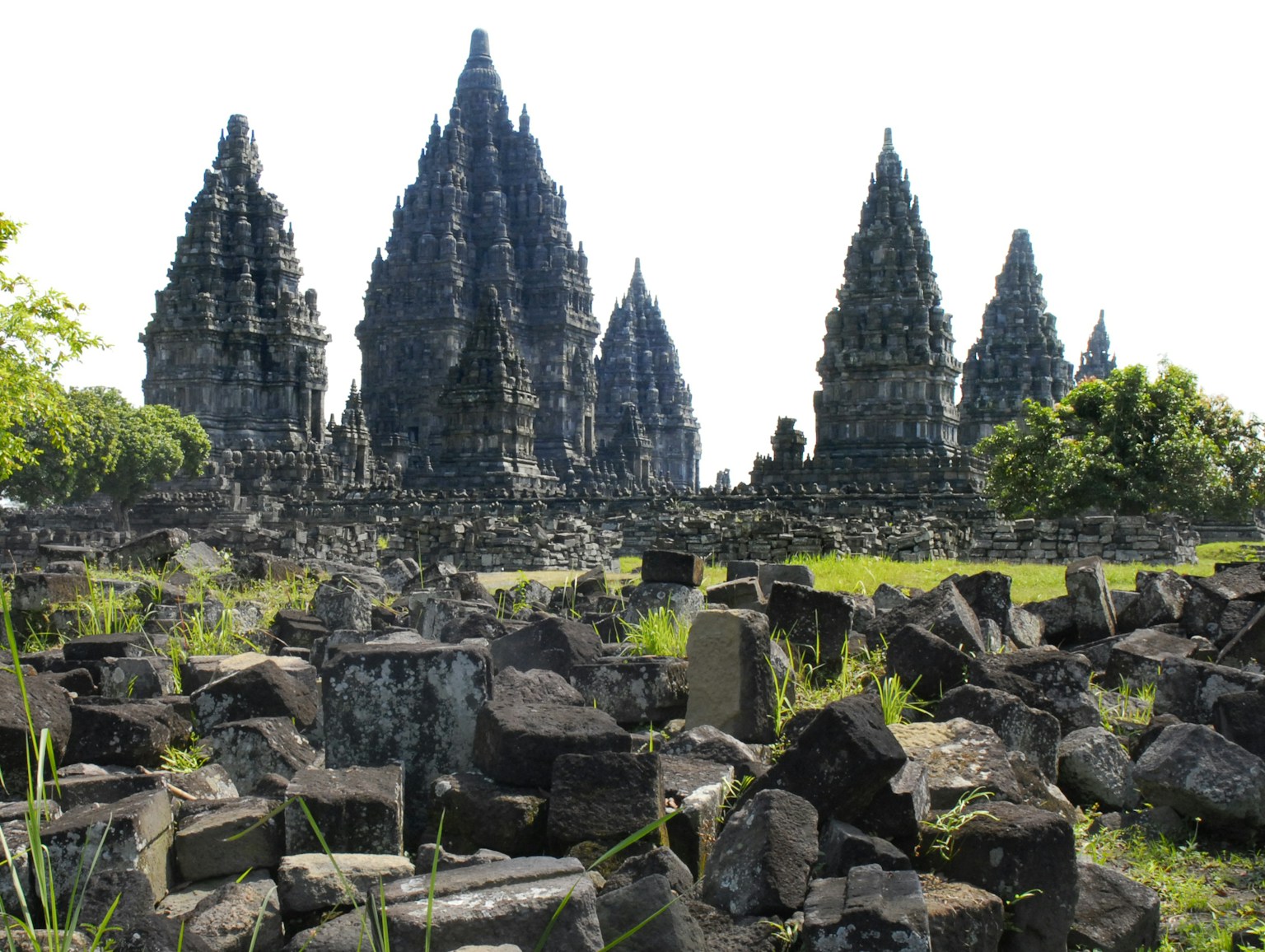 Complesso templare di Prambanan con rovine in pietra e paesaggio erboso