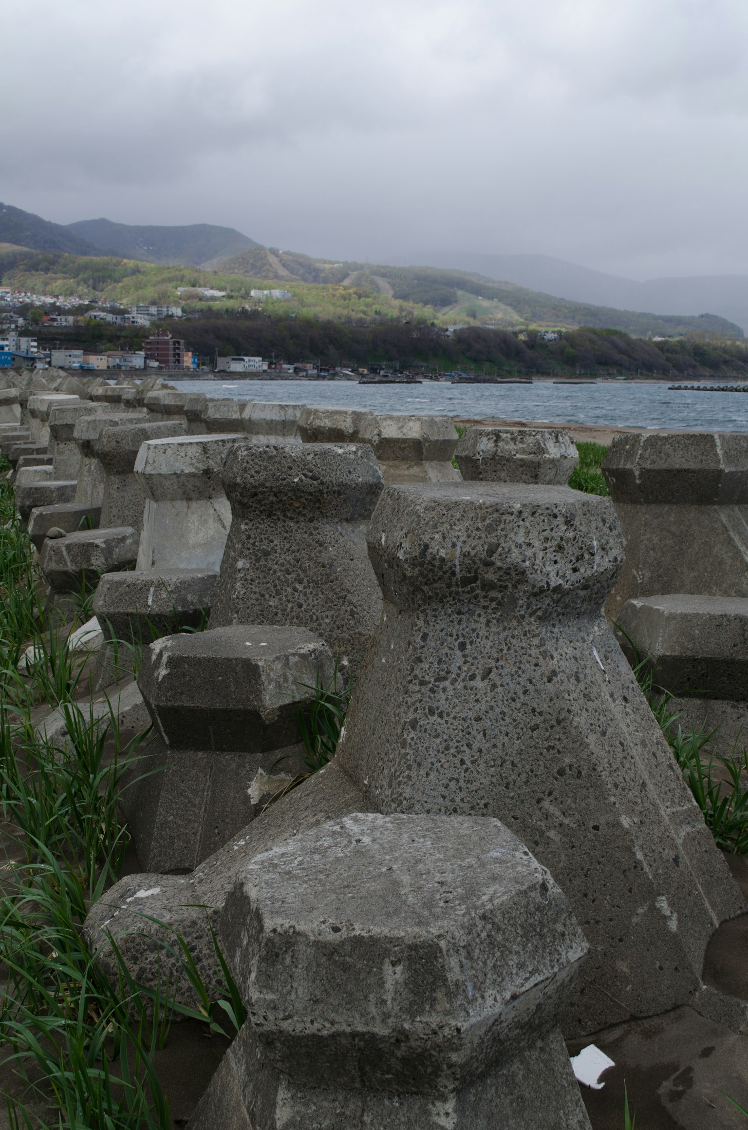 海岸混凝土块与绿地和远处的山丘