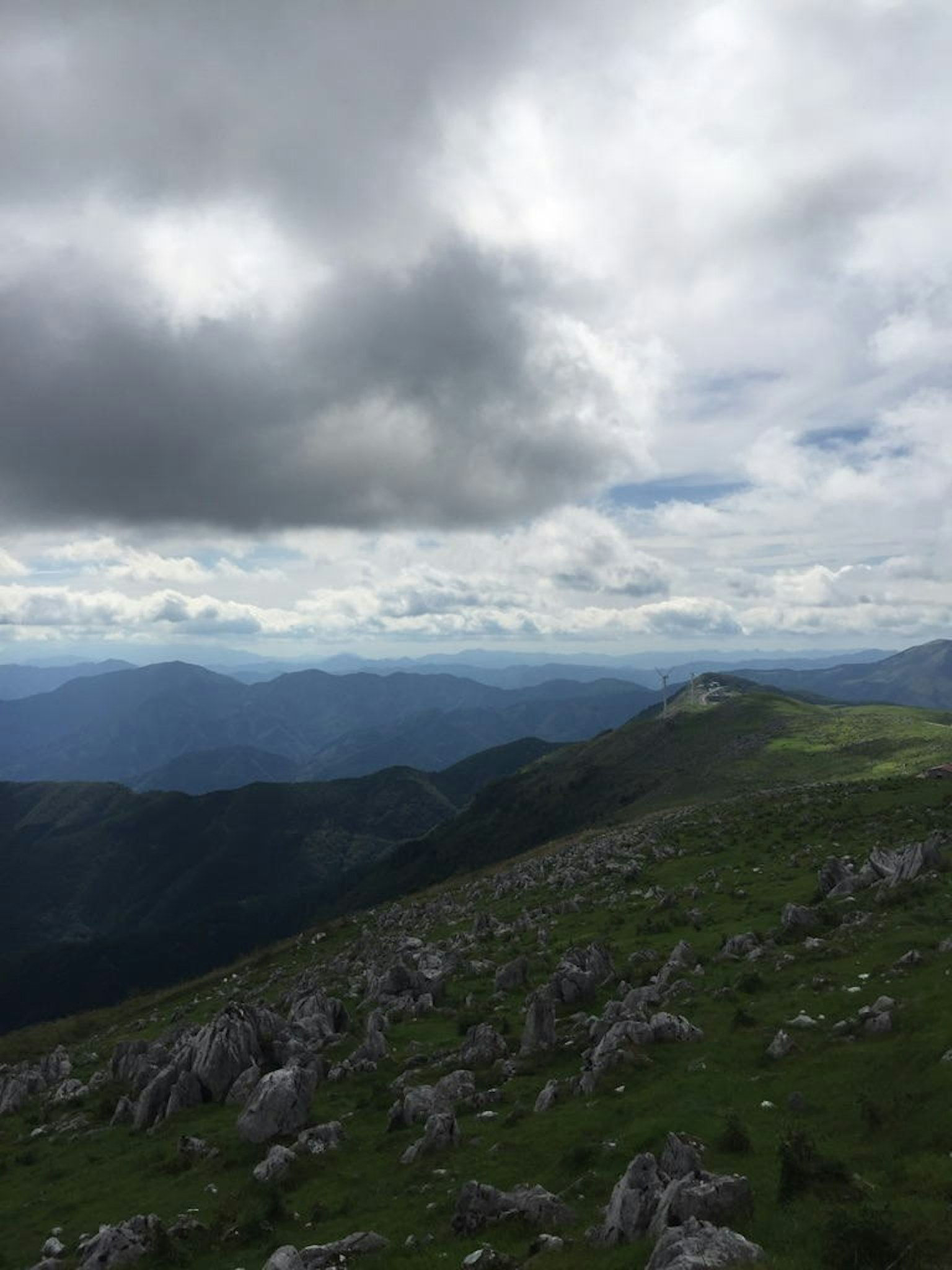 Paesaggio montano con cielo nuvoloso prati verdi e terreno roccioso