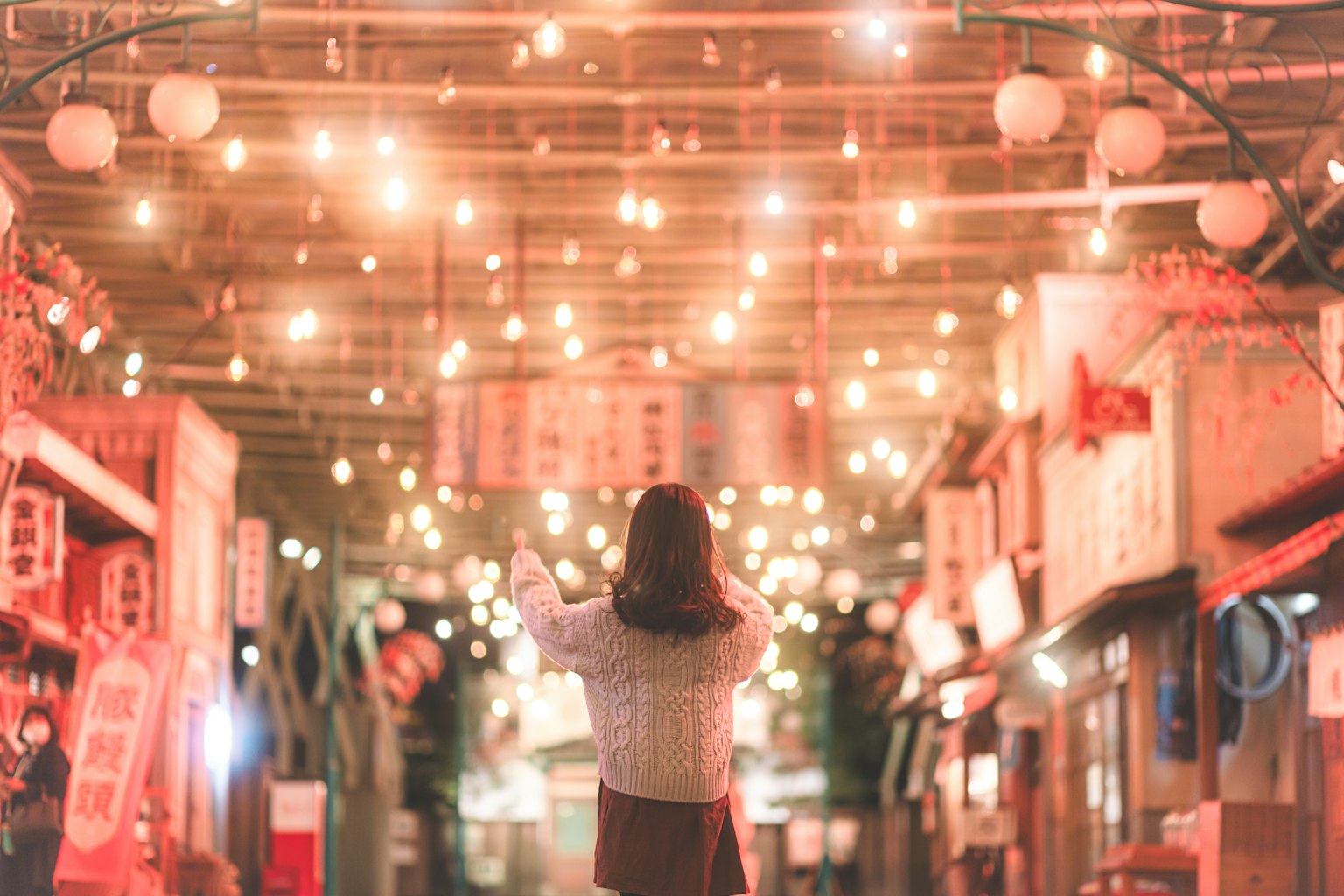 一位女性仰望著美麗照亮的戶外市場