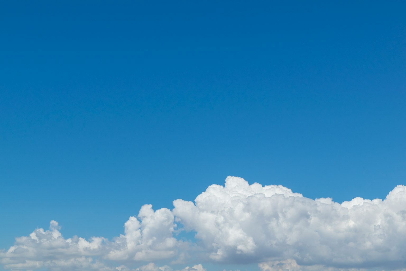 Heller blauer Himmel mit flauschigen weißen Wolken