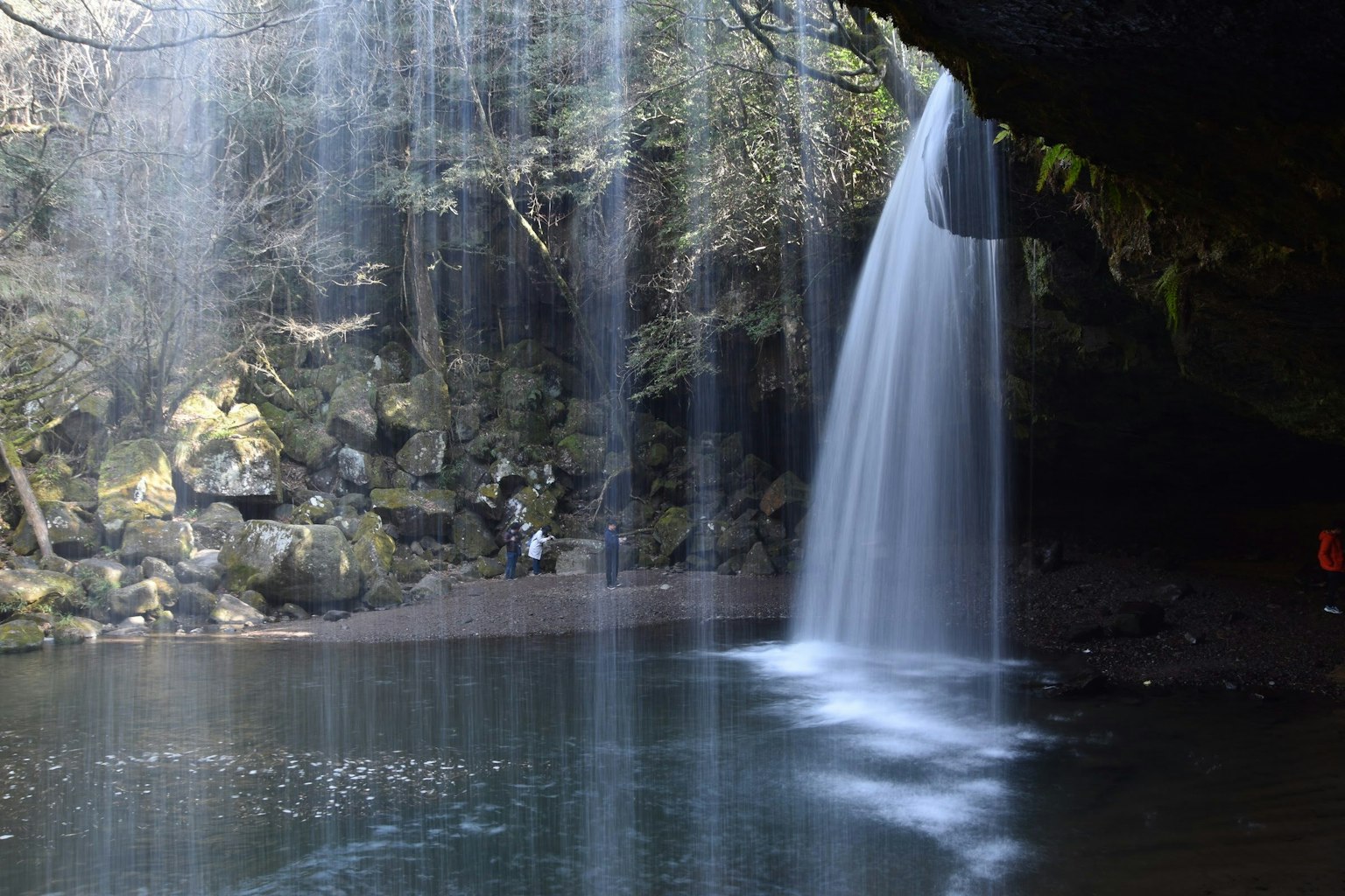 ทิวทัศน์ที่สวยงามของน้ำตกที่ตกลงสู่สระน้ำที่สงบล้อมรอบด้วยโขดหินมอส