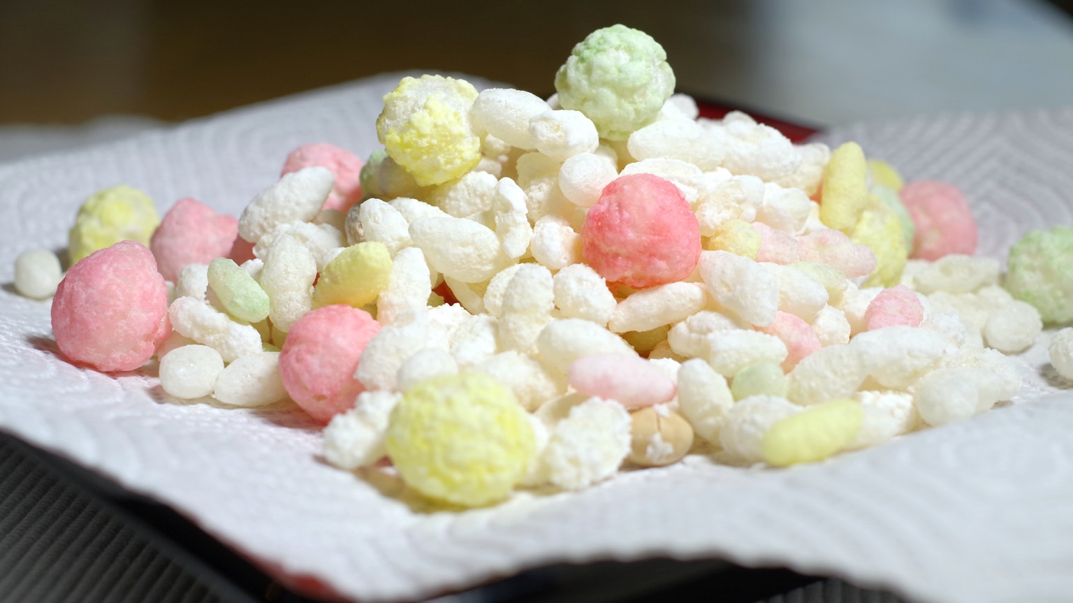 กองขนมหลากสีวางอยู่บนกระดาษขาว
