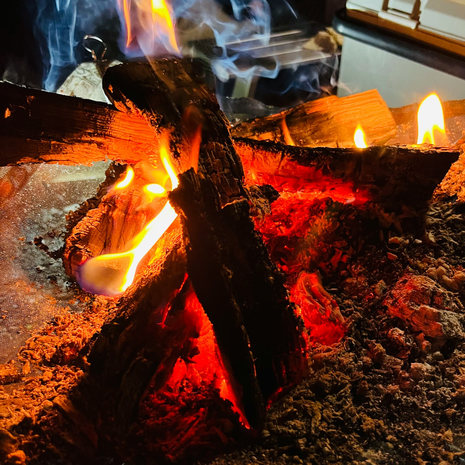 Feu chaleureux avec des flammes et de la fumée provenant du bois brûlant