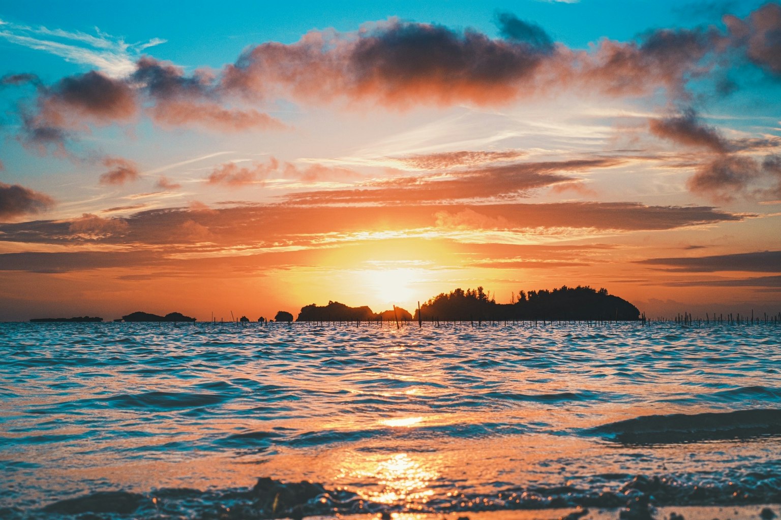 Un beau coucher de soleil sur l'océan avec des nuages colorés et des reflets sur les vagues