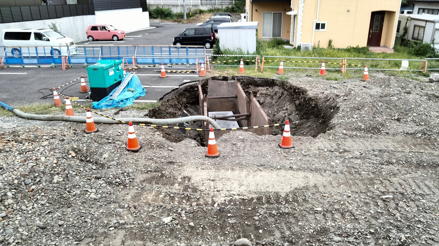 Baustelle mit einem großen Loch umgeben von Verkehrskegeln und Maschinen