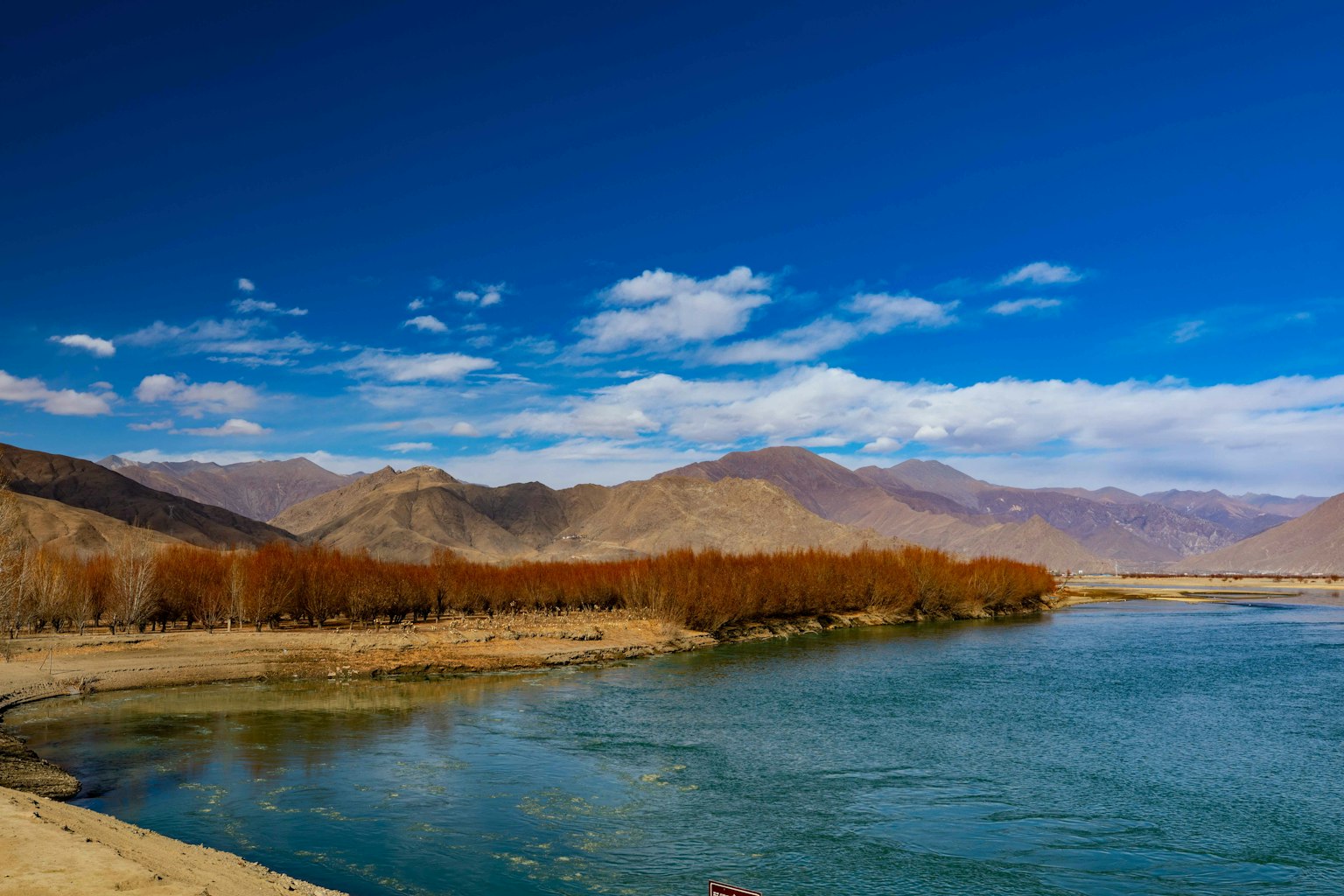 Vista panoramica di un fiume con montagne e cielo blu chiaro