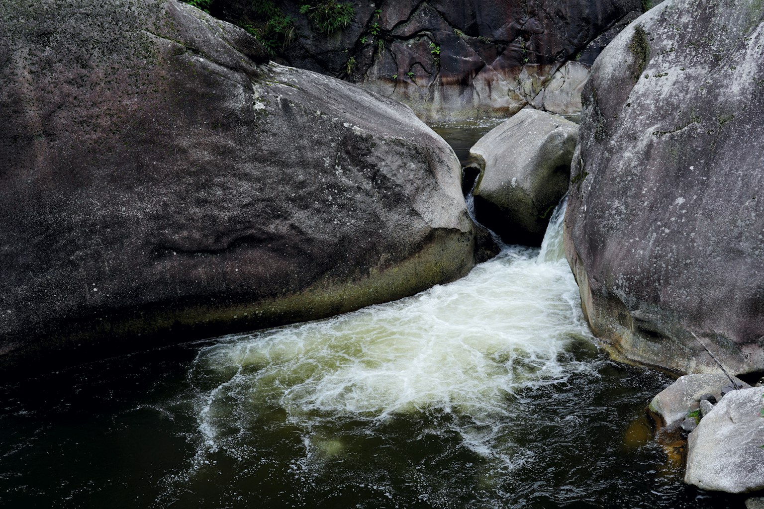 Acqua che scorre tra grandi rocce in un ambiente naturale