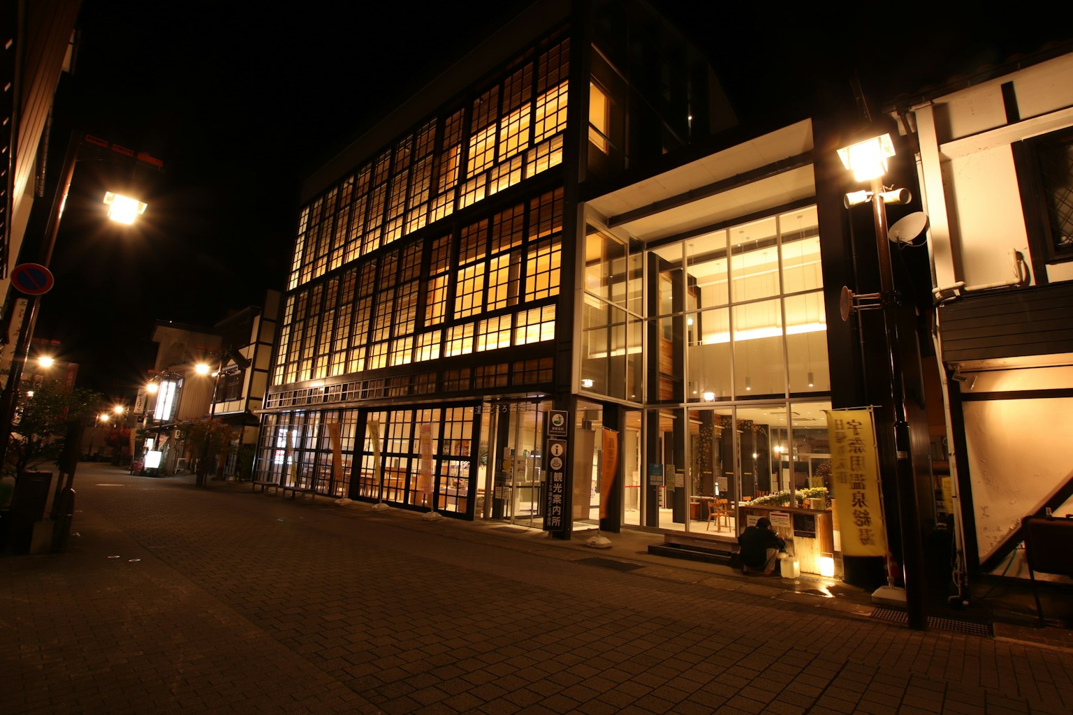Façade d'un bâtiment moderne la nuit avec des lumières chaudes