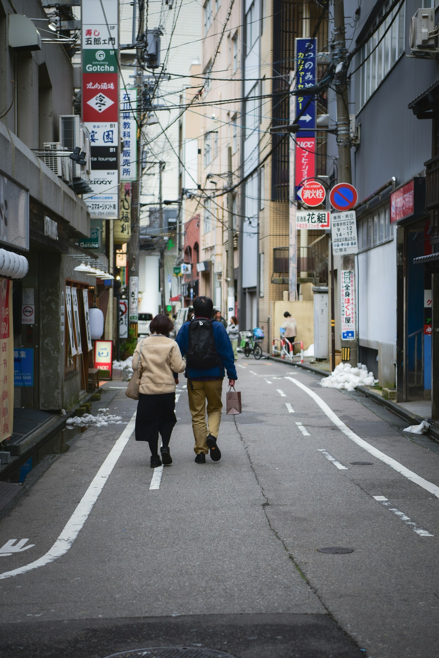 Dos personas caminando por un callejón estrecho en un entorno urbano