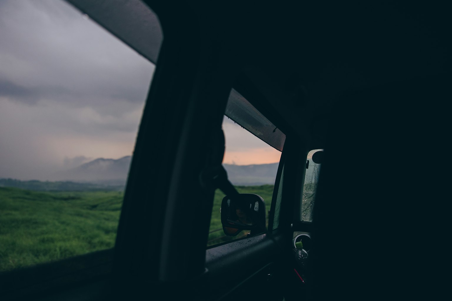 Vue du paysage verdoyant et du ciel nuageux depuis la fenêtre de la voiture