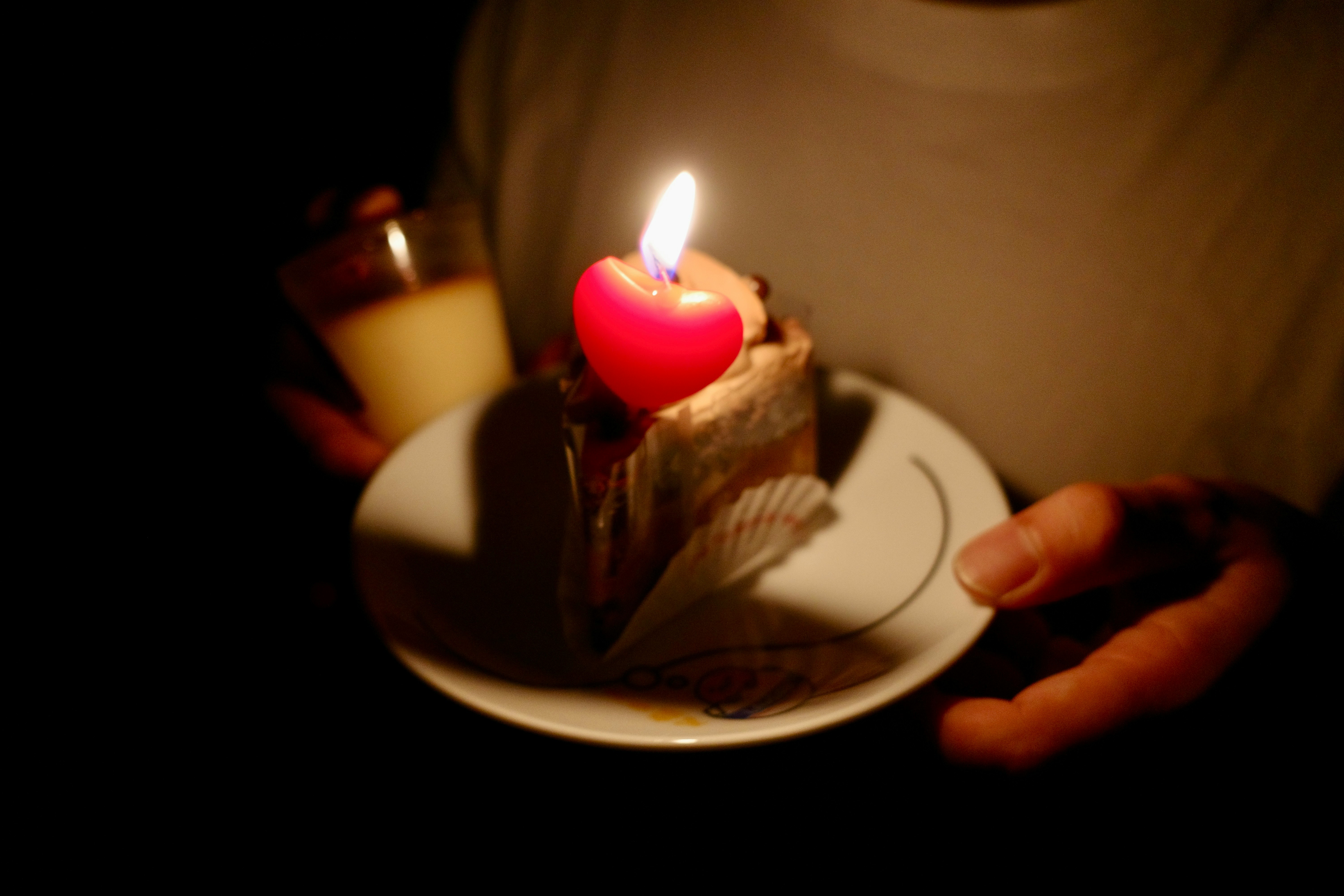 ろうそくの灯る食卓でケーキを切る手元