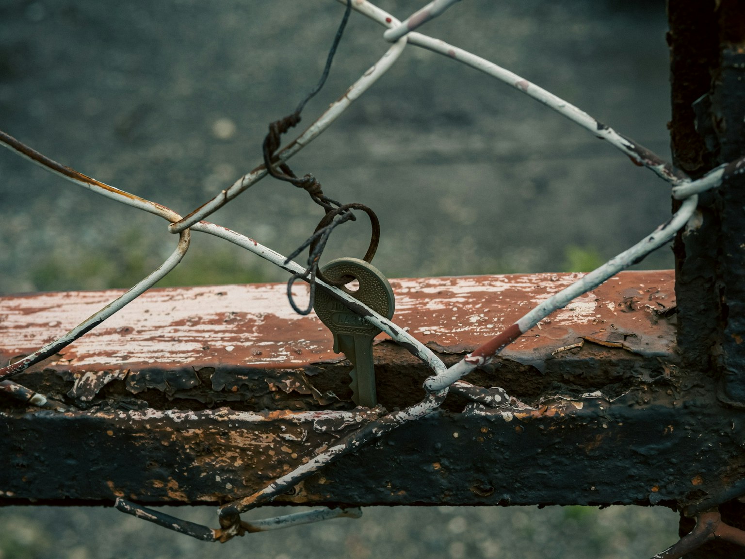 Close-up of a rusty metal fence with an old key