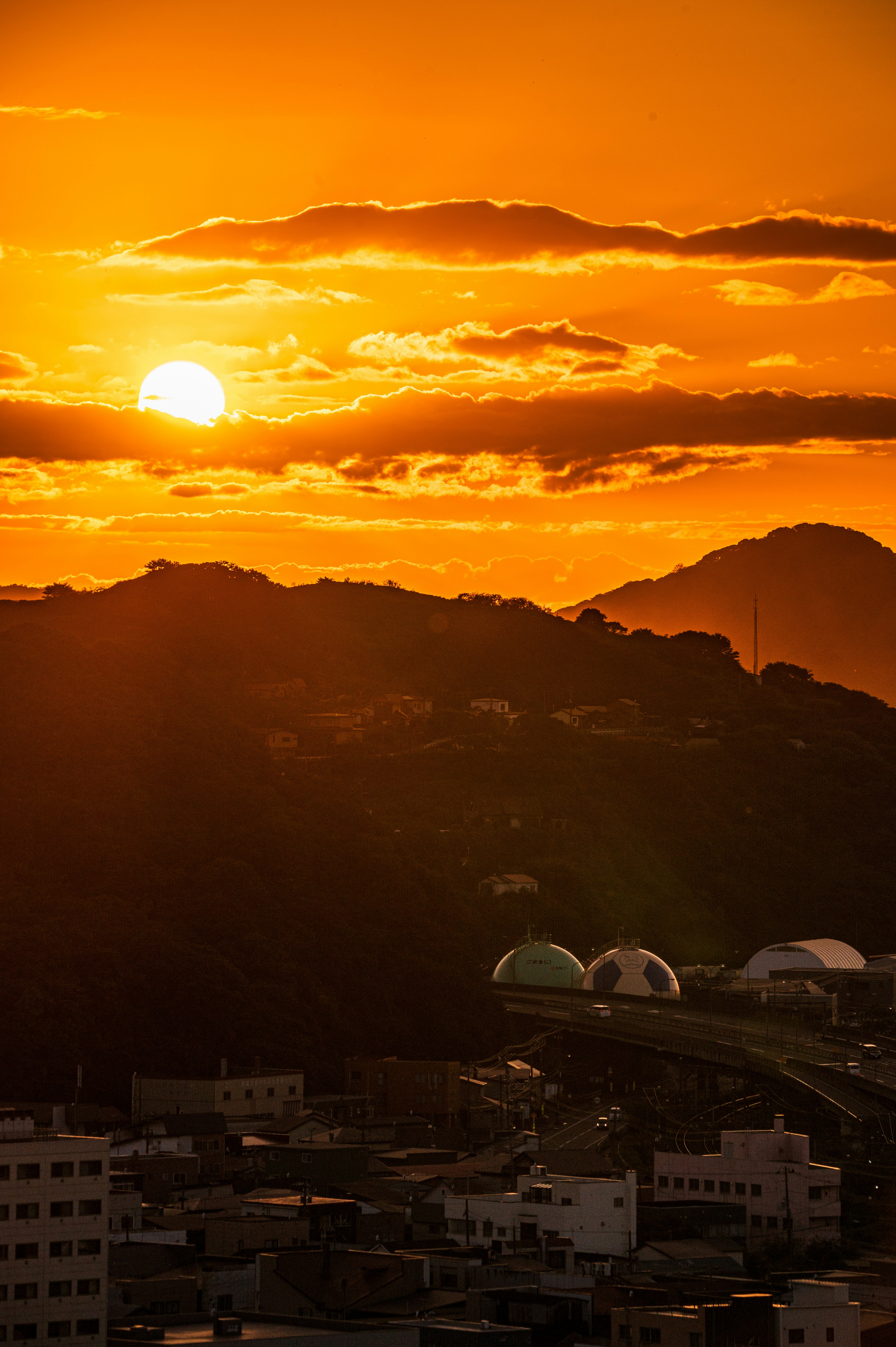 山並みと街並みを見下ろす夕焼けの空