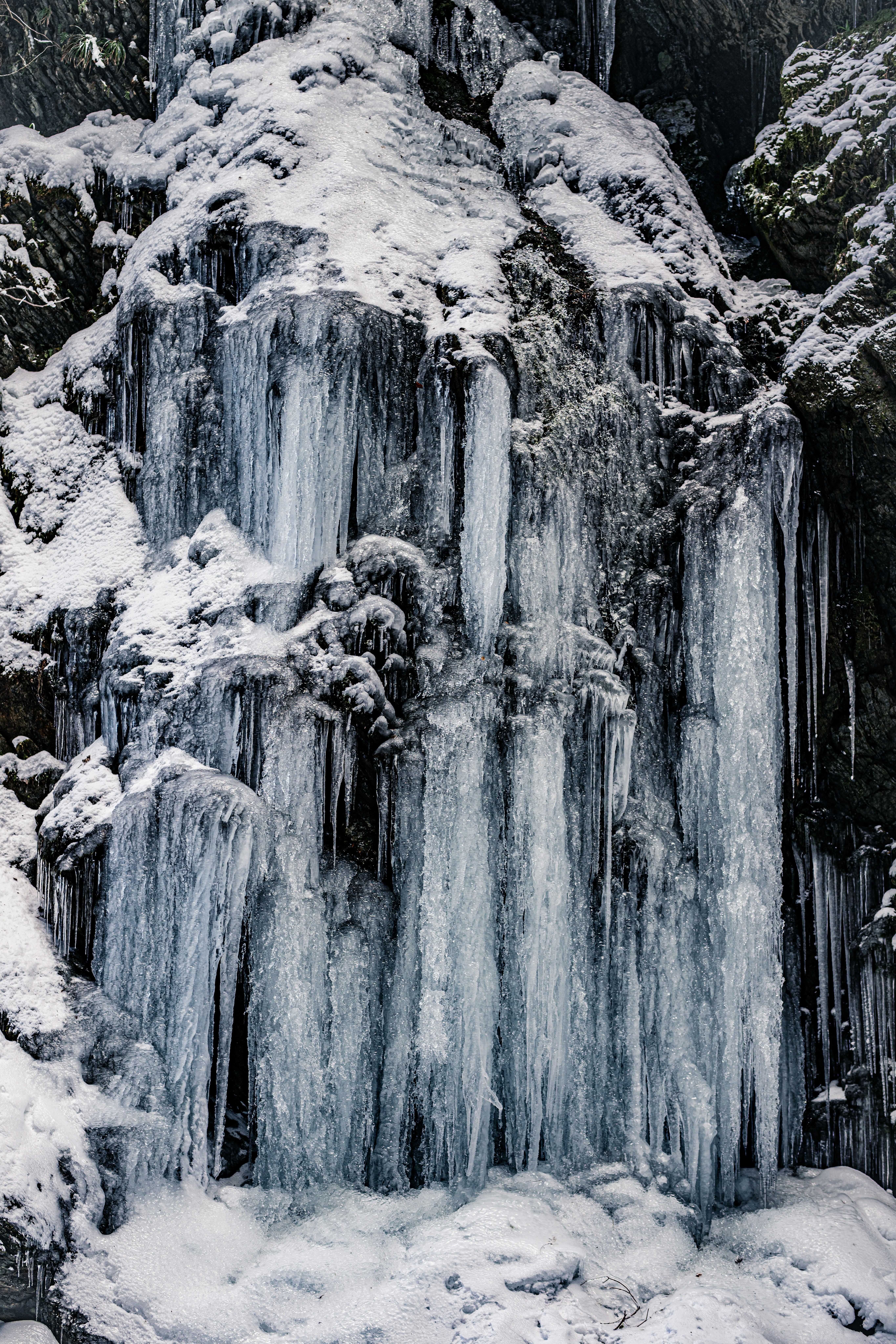 氷の滝が雪に覆われた岩に形成されている美しい冬の風景