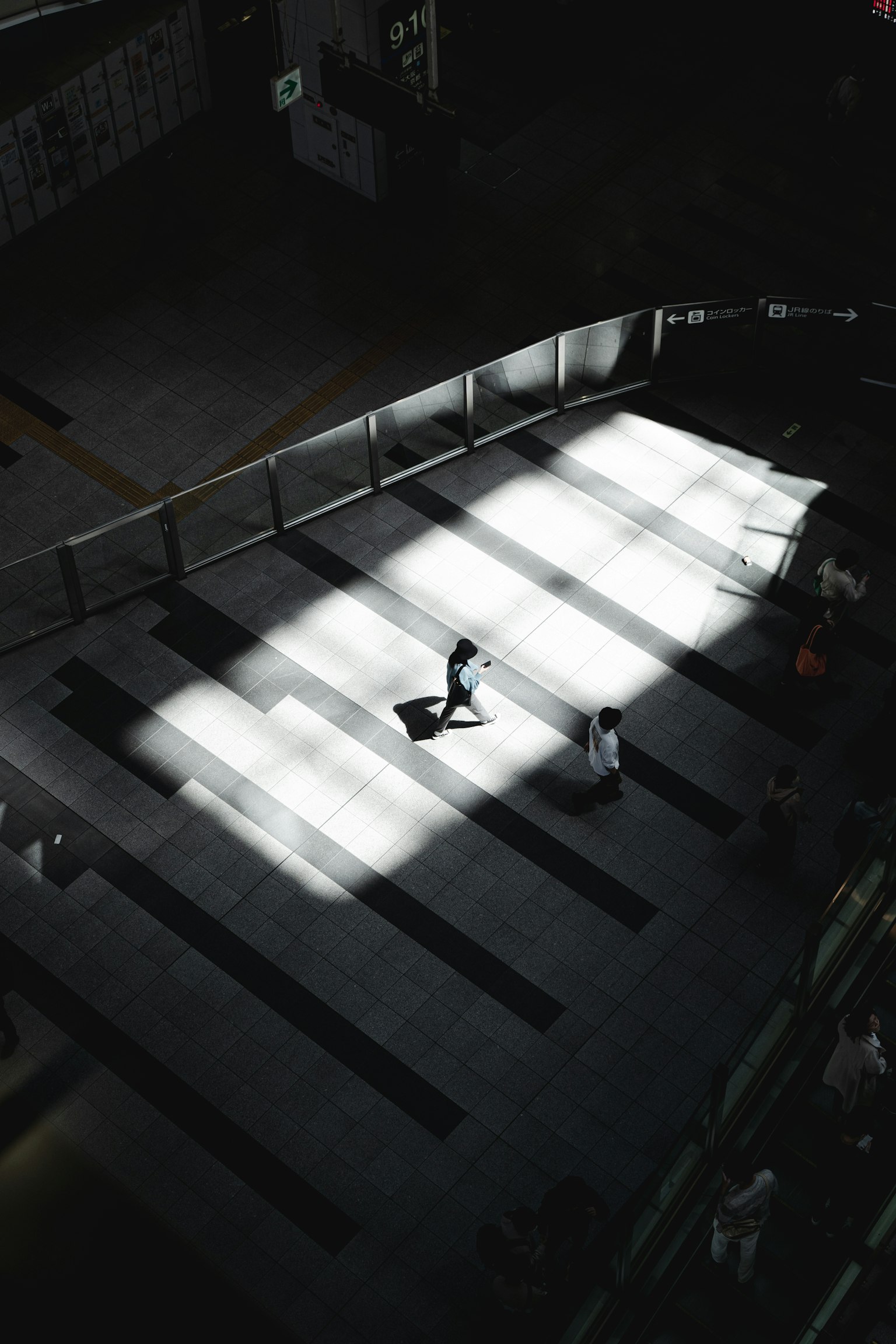 ทิวทัศน์ในเมืองที่มีผู้คนเดินในแสงและเงาที่ตัดกัน