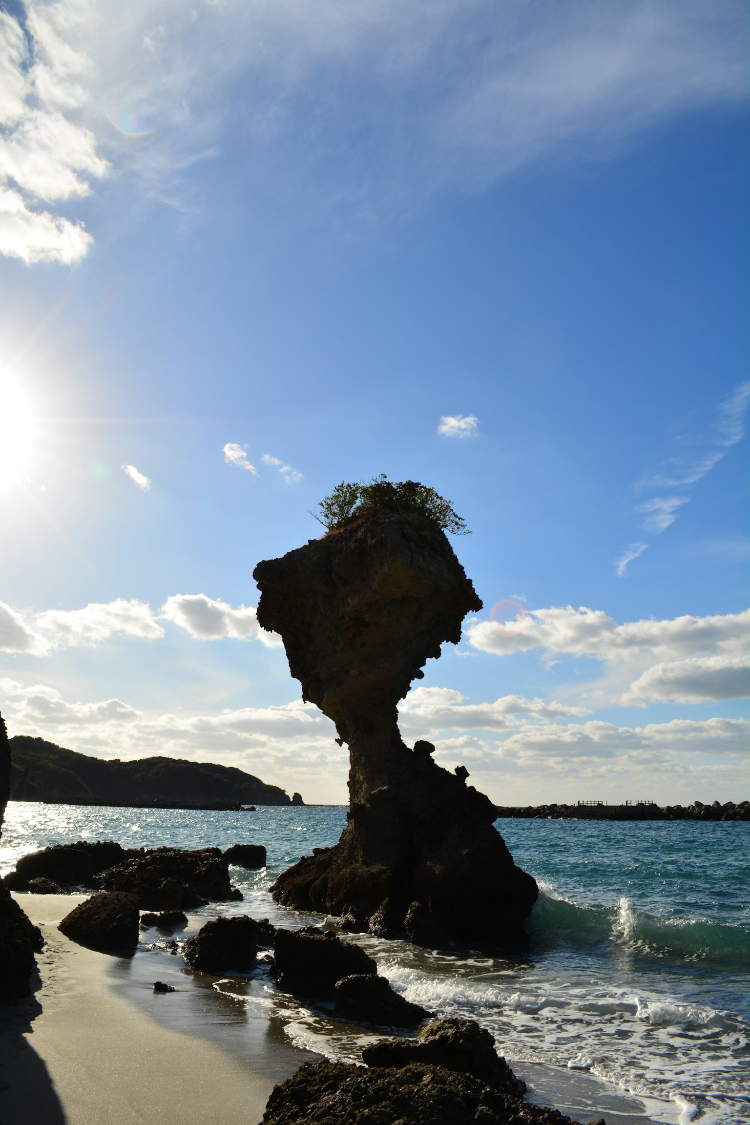 奇形岩石矗立在海岸上与蓝天