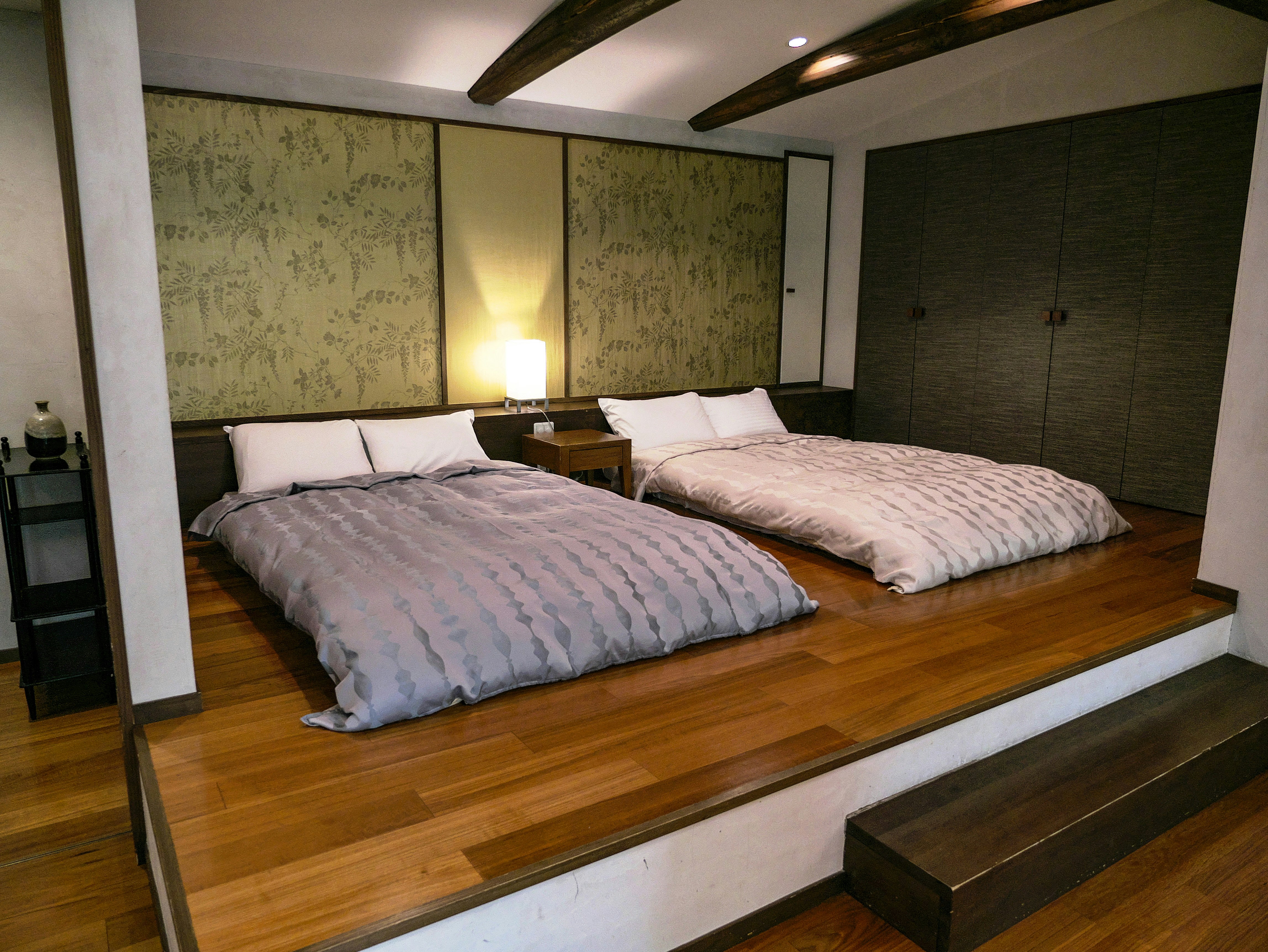 kamar tidur modern dengan dua tempat tidur di atas platform kayu
