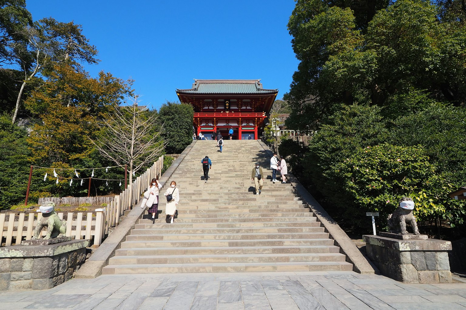 Stone steps leading to a red shrine surrounded by greenery