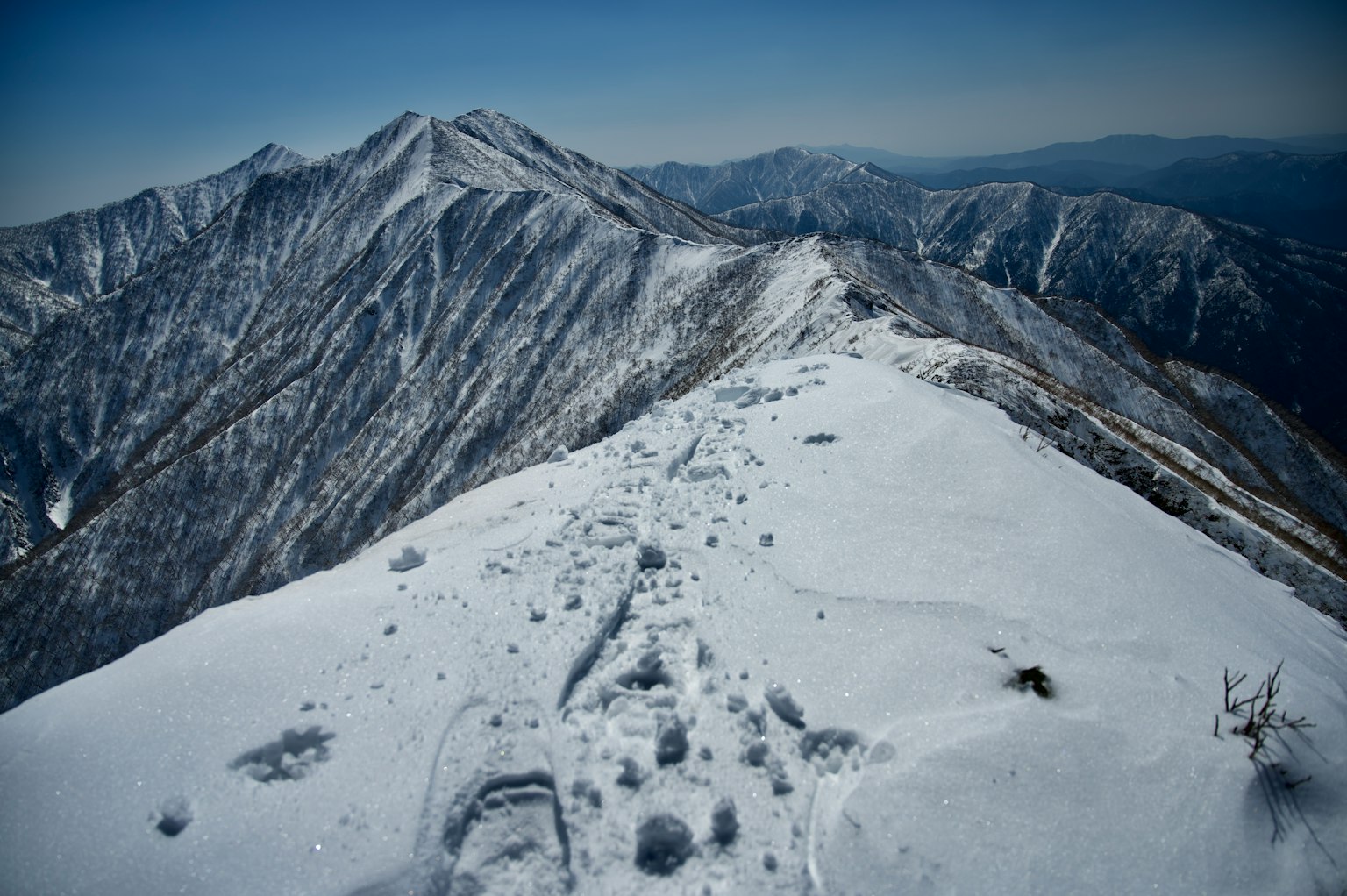 被雪覆盖的山峰风景，远处有连绵的山脉