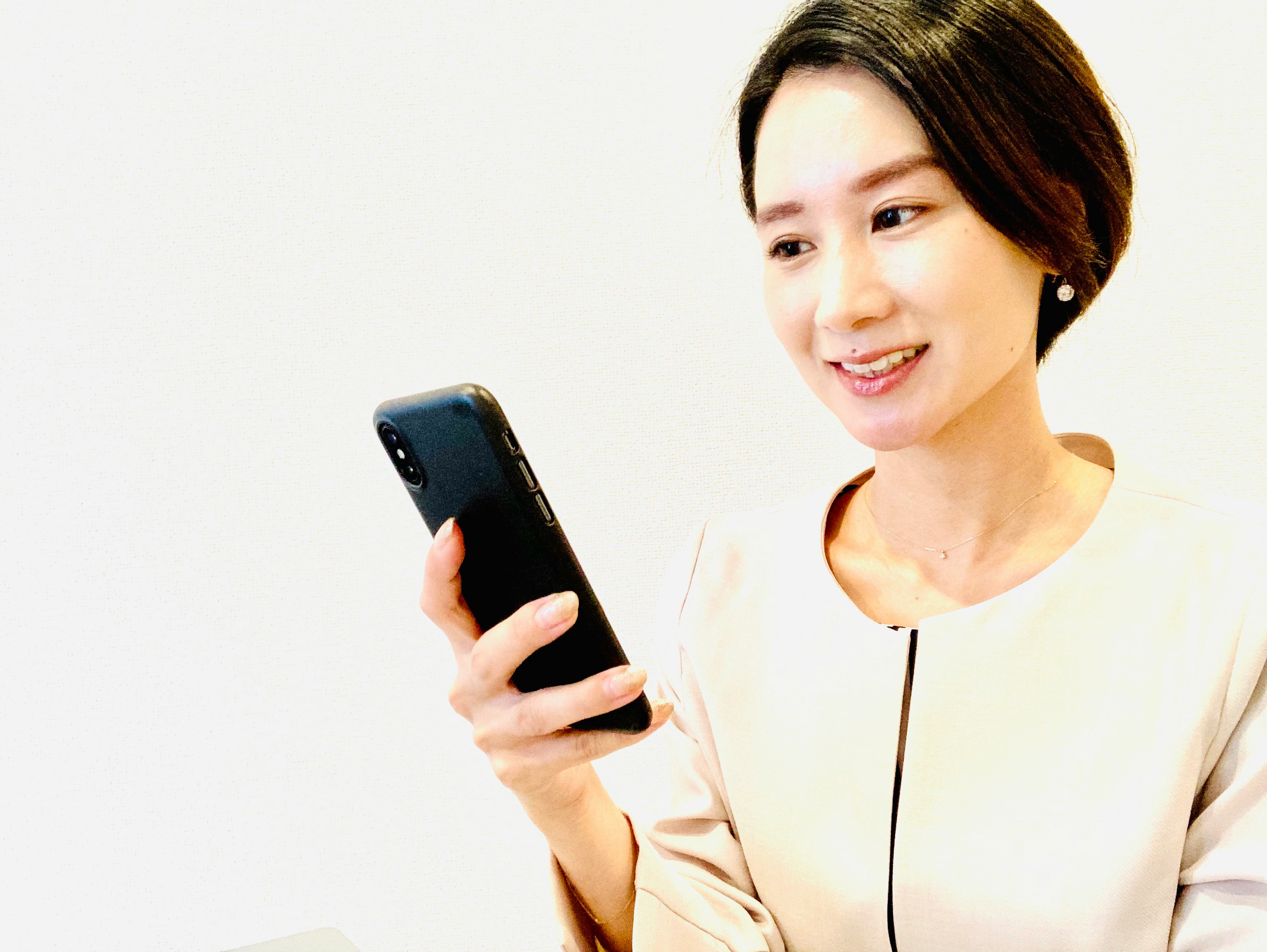 スマホを手に笑顔の女性