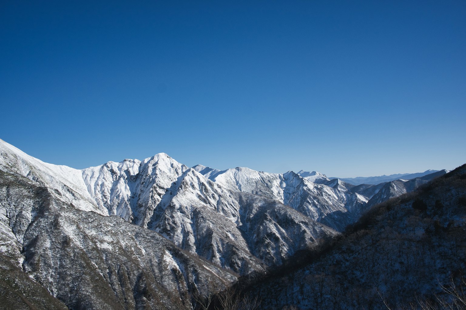 맑은 파란 하늘 아래 눈 덮인 산들