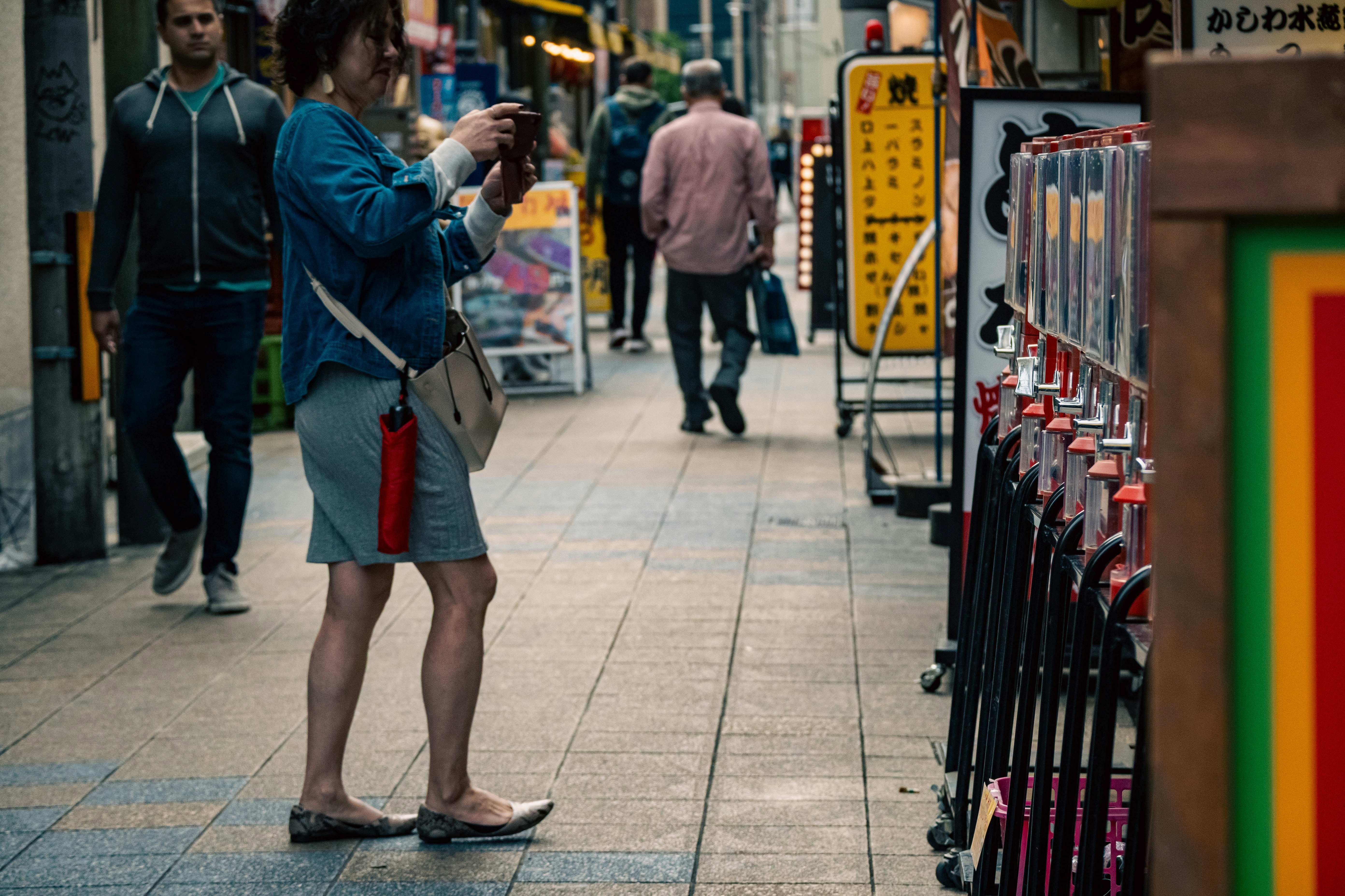 止まった午後の街角でスマホを見つめる人のある路地の風景