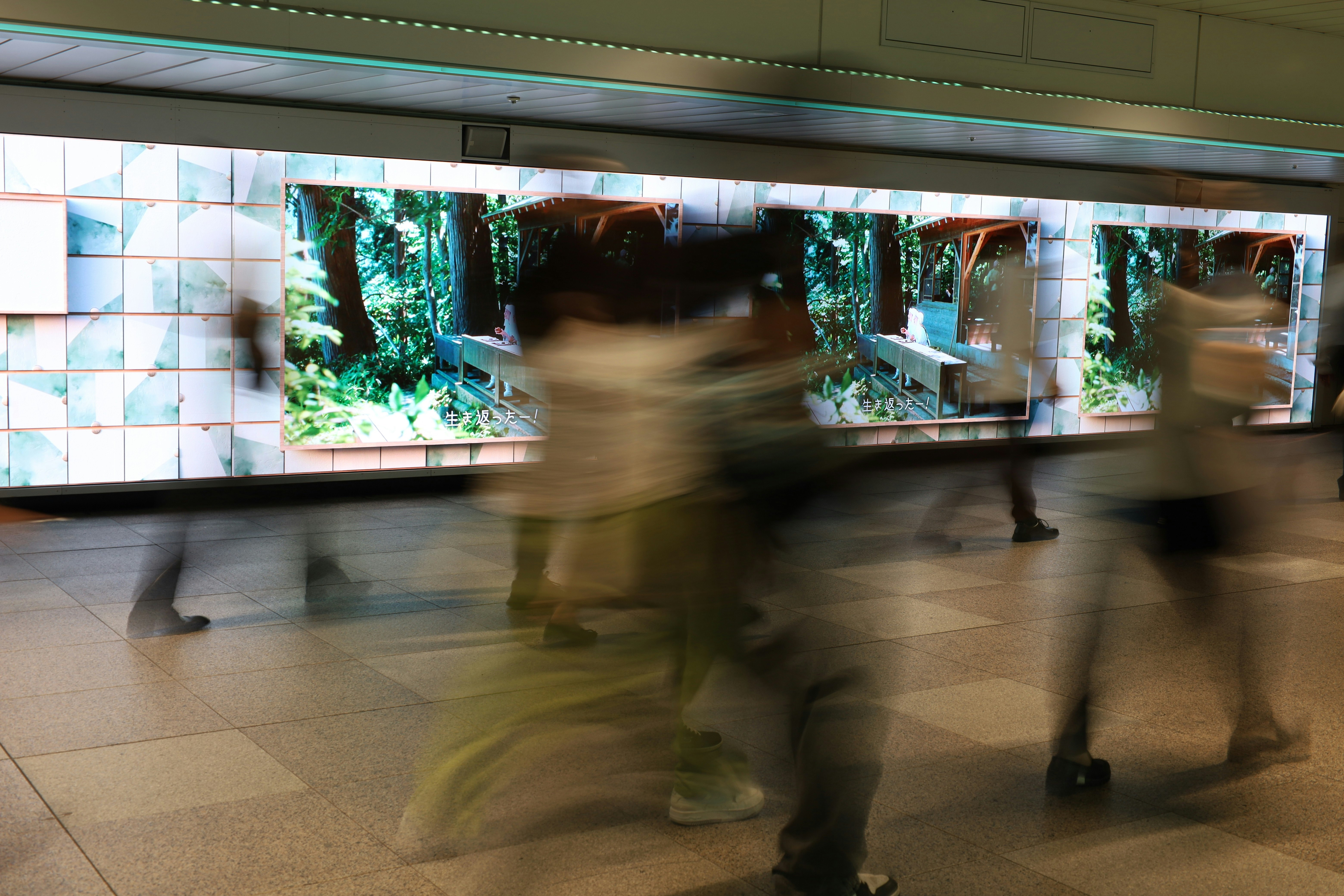 新宿の地下通路で人が流れるモーションブラーのある通路風景