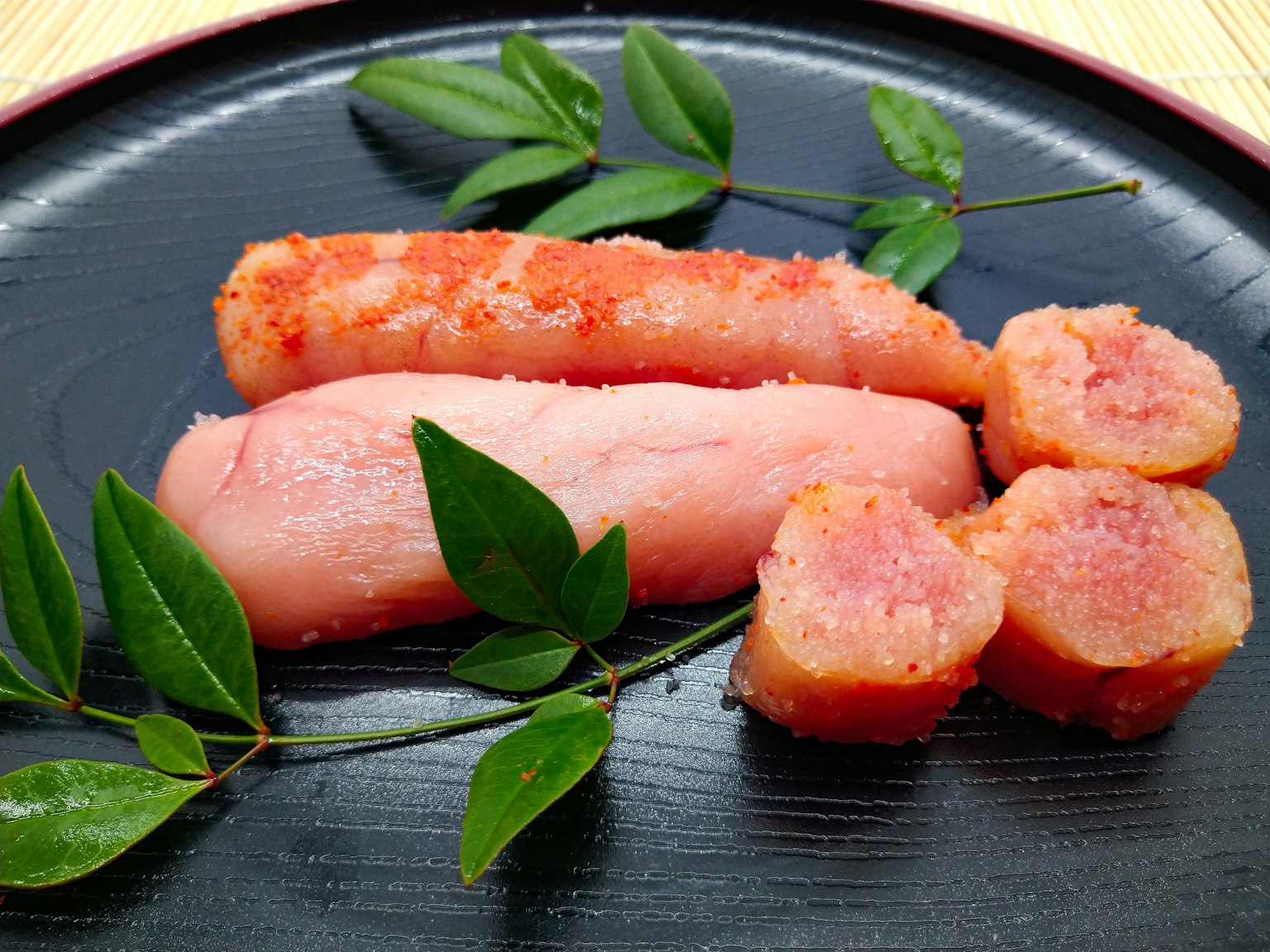 Piatto con uova di pesce rosa e foglie verdi