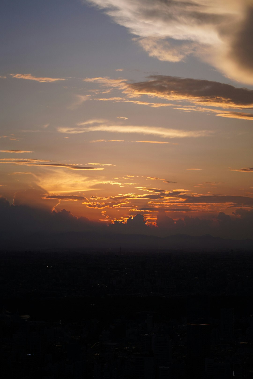 Wolken beim Sonnenuntergang am Himmel mit silhouettierter Horizontlinie