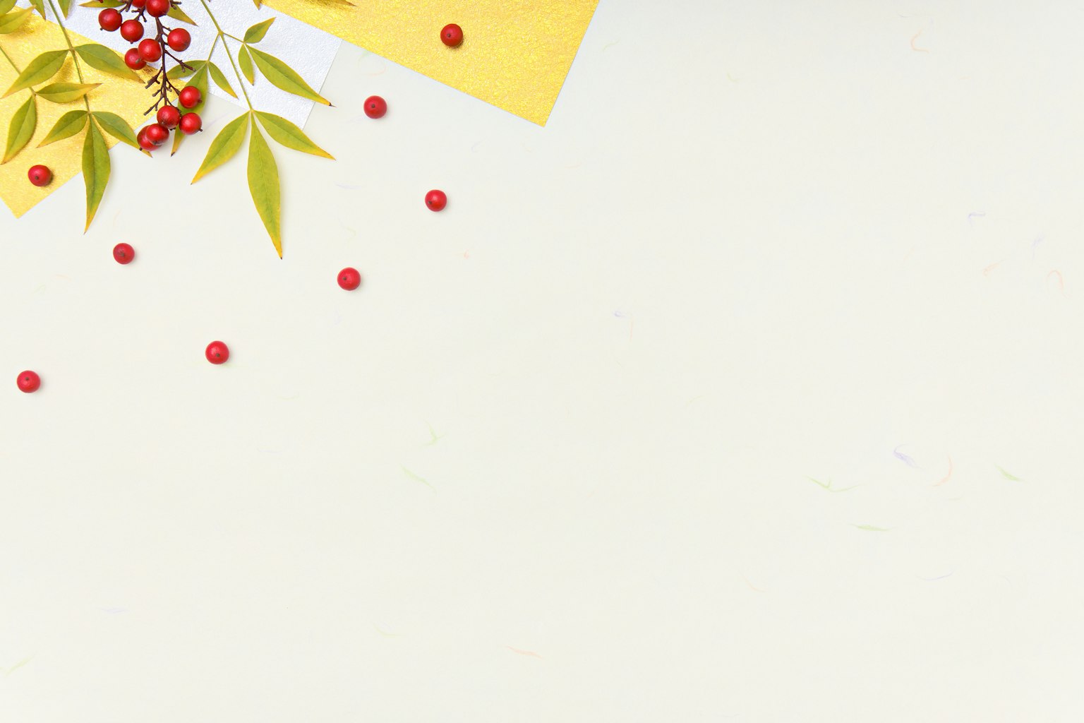 Einfacher Hintergrund mit gelbem Papier und verstreuten grünen Blättern mit roten Beeren