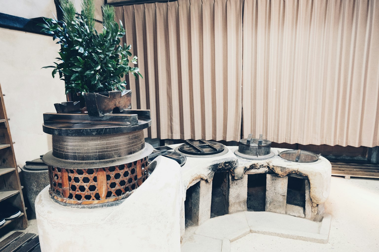 室內景觀，展示傳統烹飪器具和一盆植物