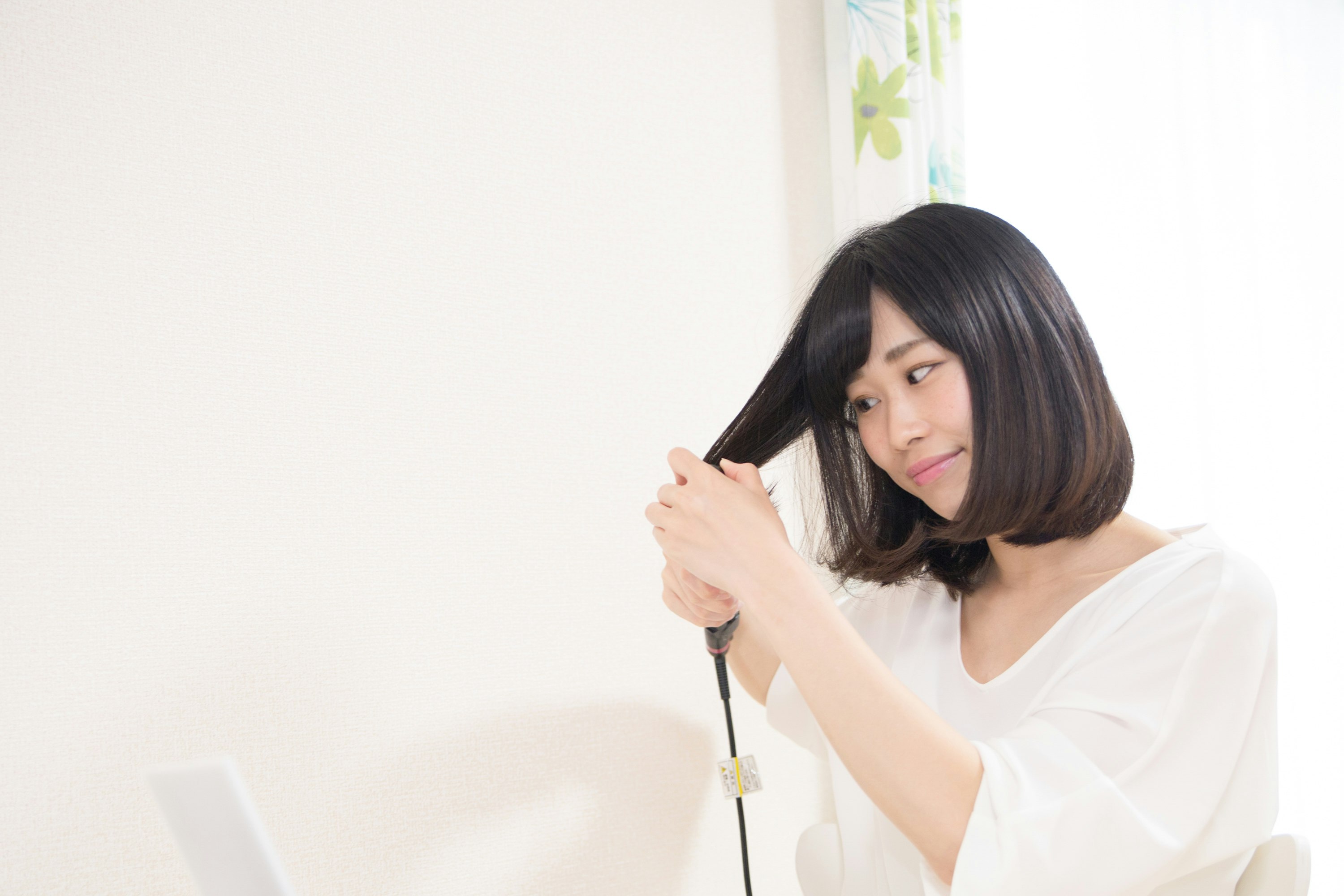 mujer ajustándose el cabello sobre fondo blanco
