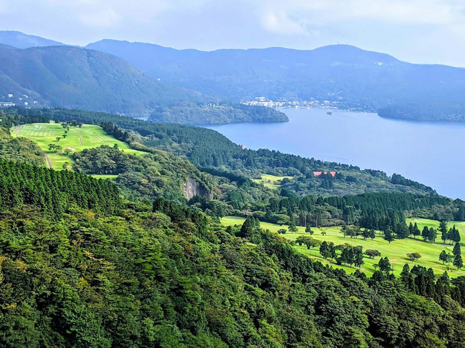Malersicher Blick auf einen See, umgeben von grünen Hügeln