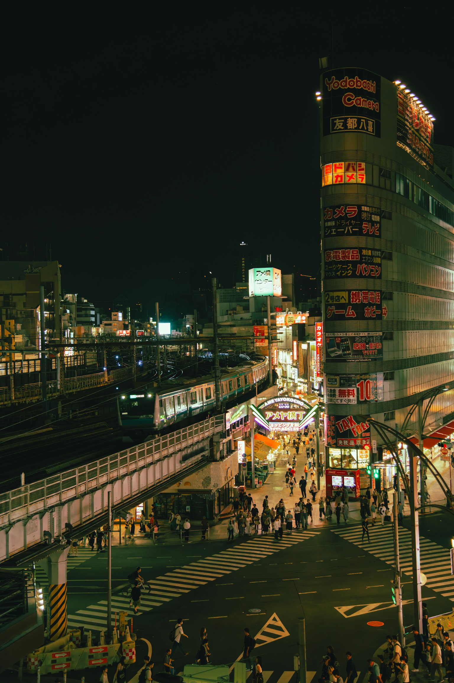 Vibrant cityscape at night featuring busy streets and railway