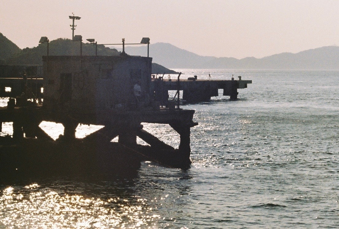 海沿いの桟橋と波打つ水面の夕景