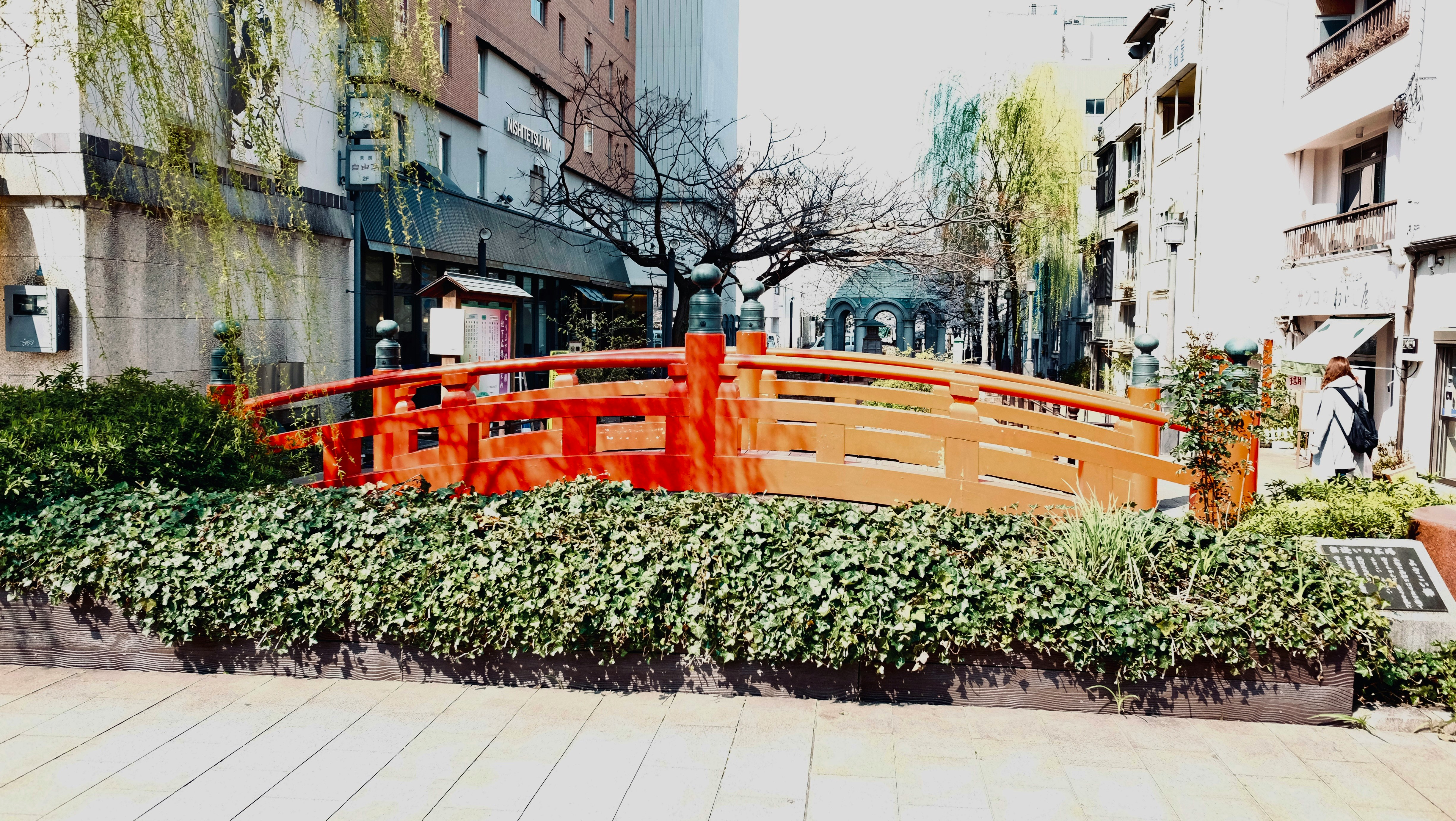 赤い欄干の橋と街並みが並ぶ観光地の風景