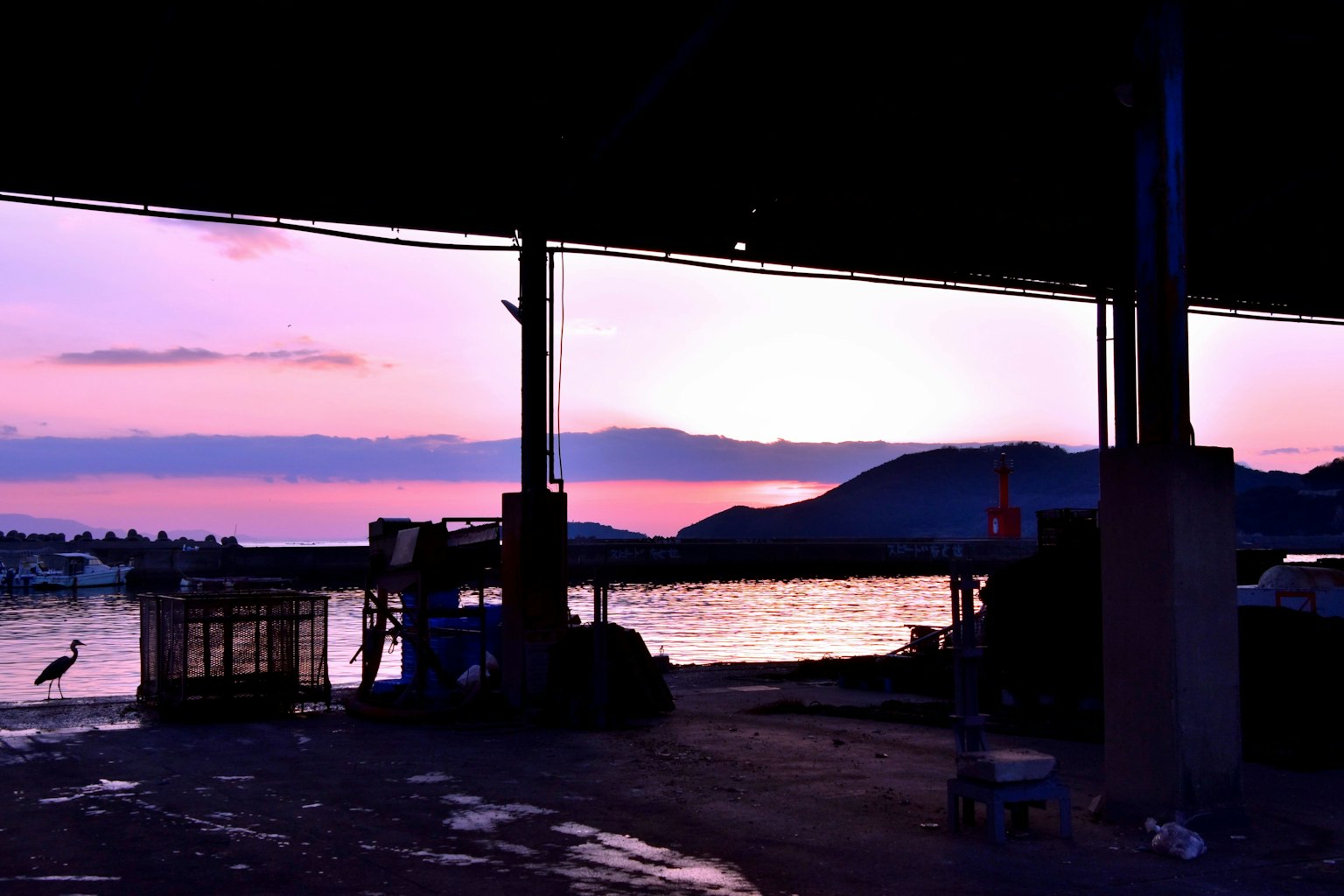 Silhouette di una scena portuale sotto i colori del tramonto