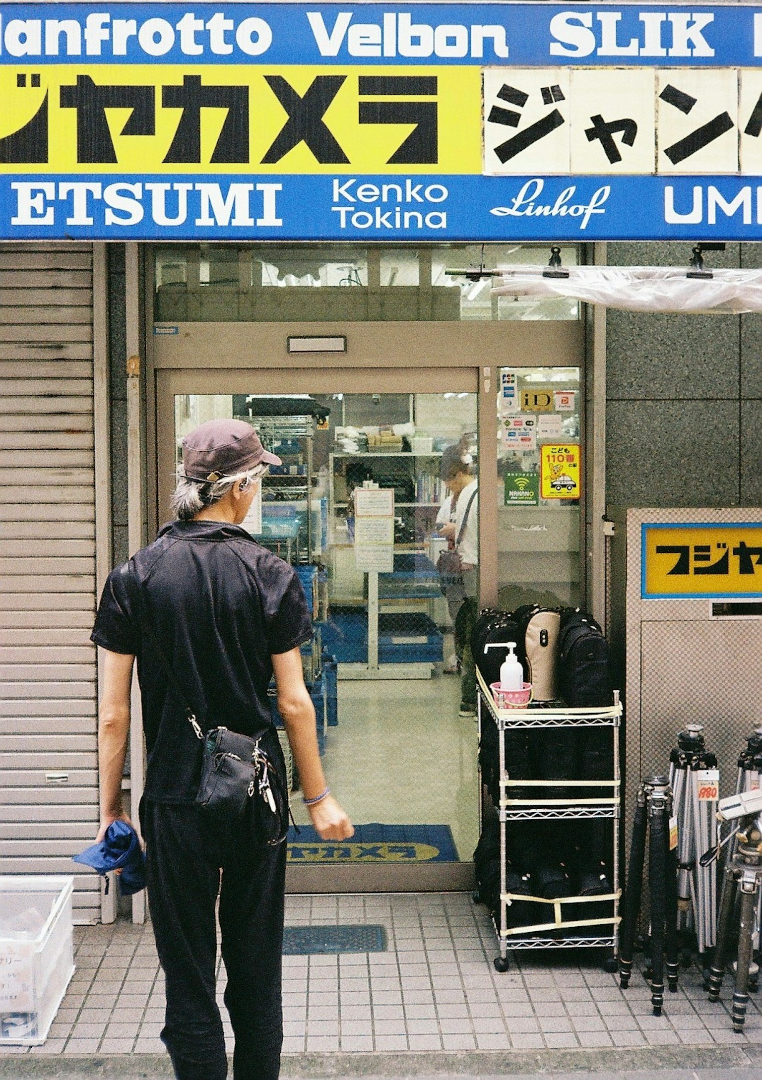 穿著黑色衣服的男人站在相機設備商店前